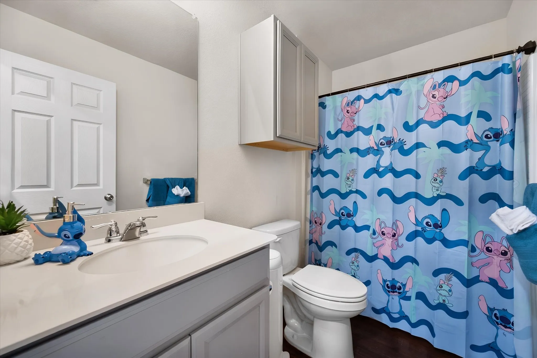 Vanity with an integrated sink and chrome faucet, full-width mirror, panel-style door, and built-in storage cabinet