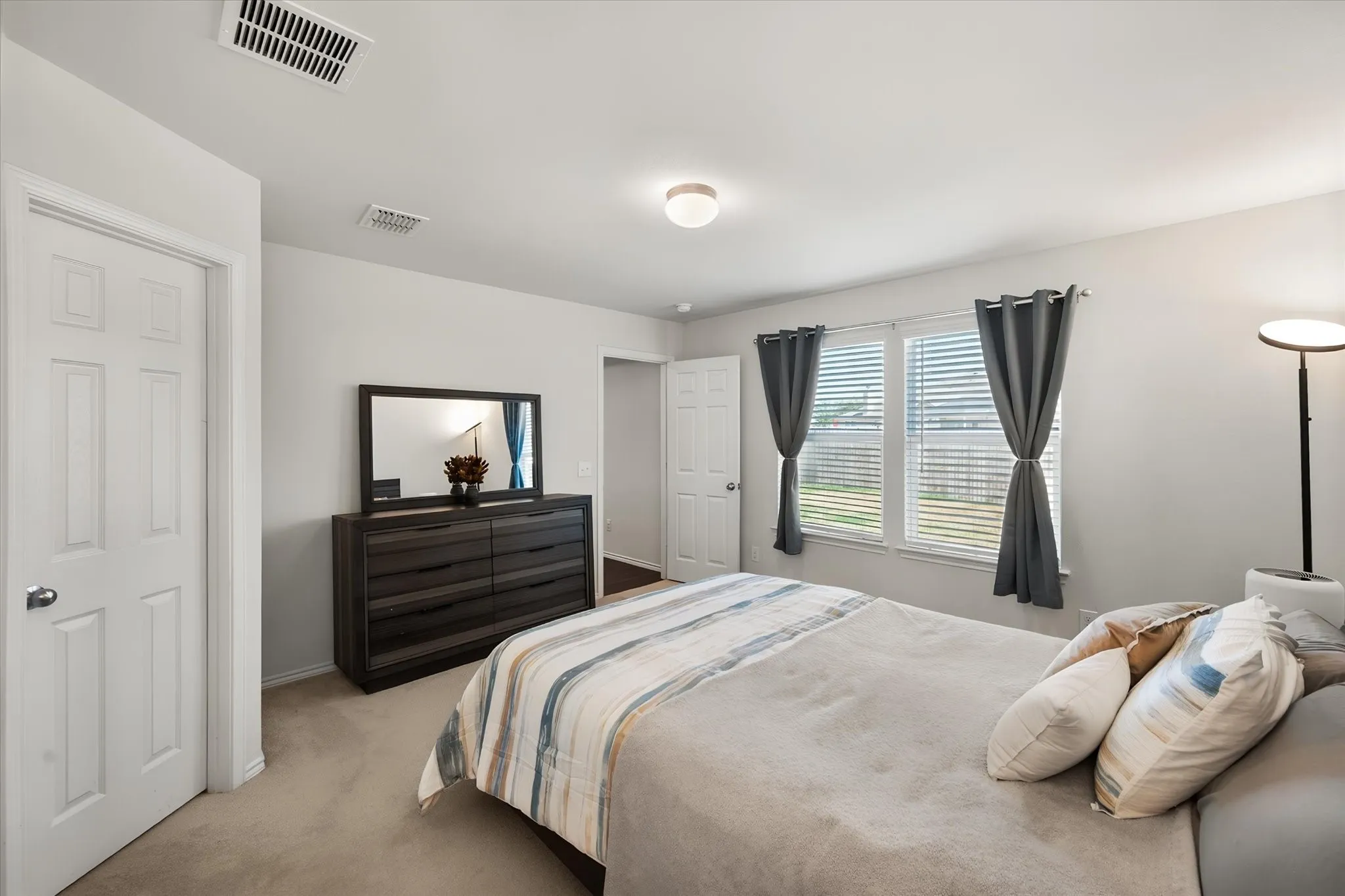 Carpeted flooring, white walls, two panel doors, and a ceiling-mounted light fixture