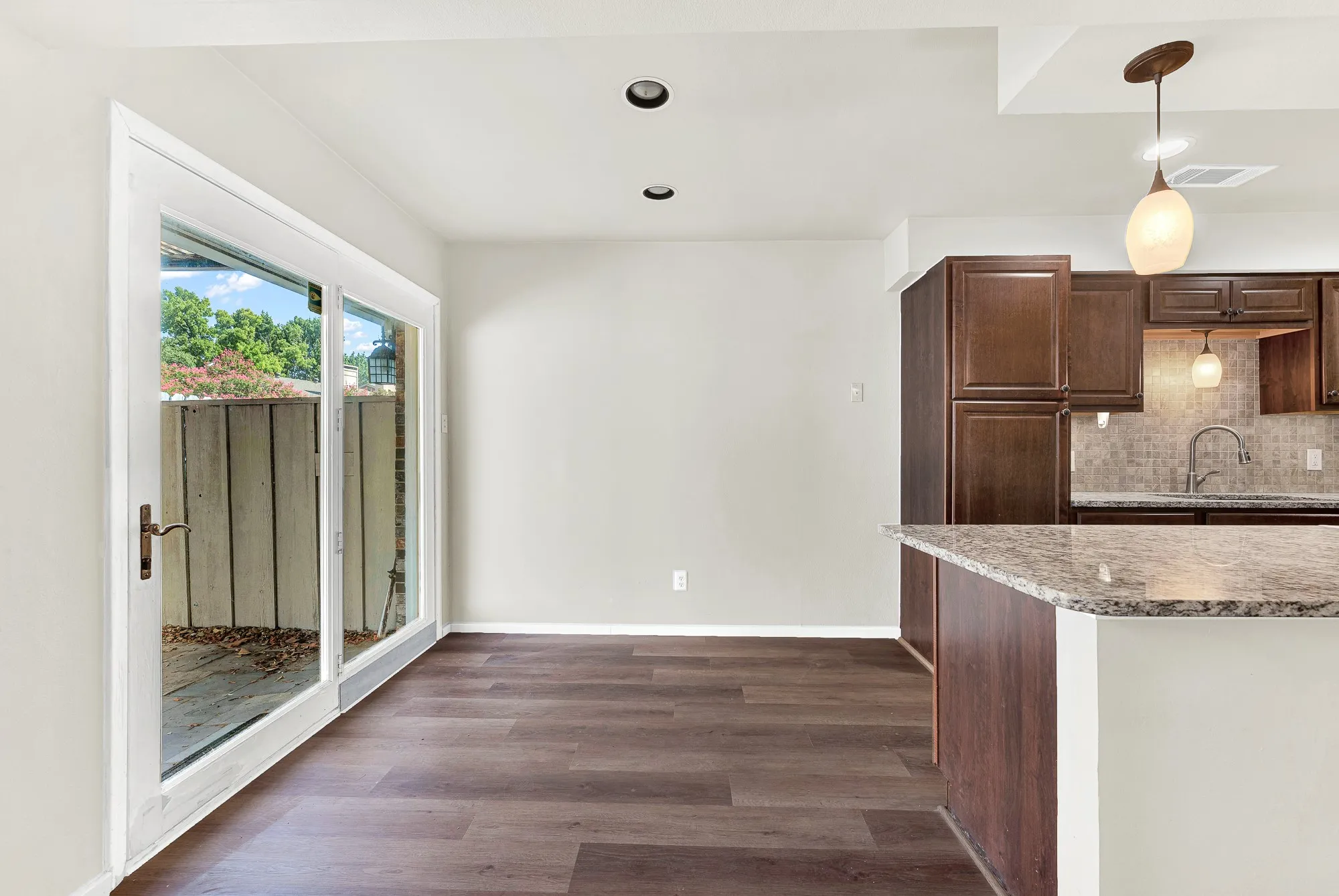 Wood-finish flooring, recessed lighting, and sliding glass doors