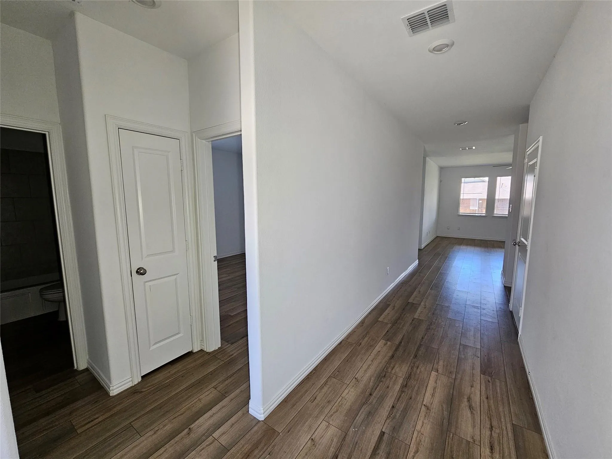 Wood-finish flooring throughout, recessed ceiling lighting, white interior doors, and neutral wall paint