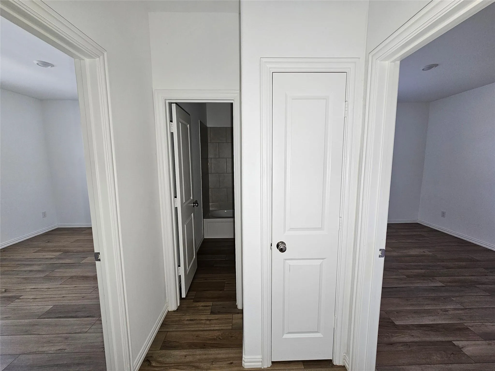 Wood-finish flooring throughout, white interior doors, and recessed lighting