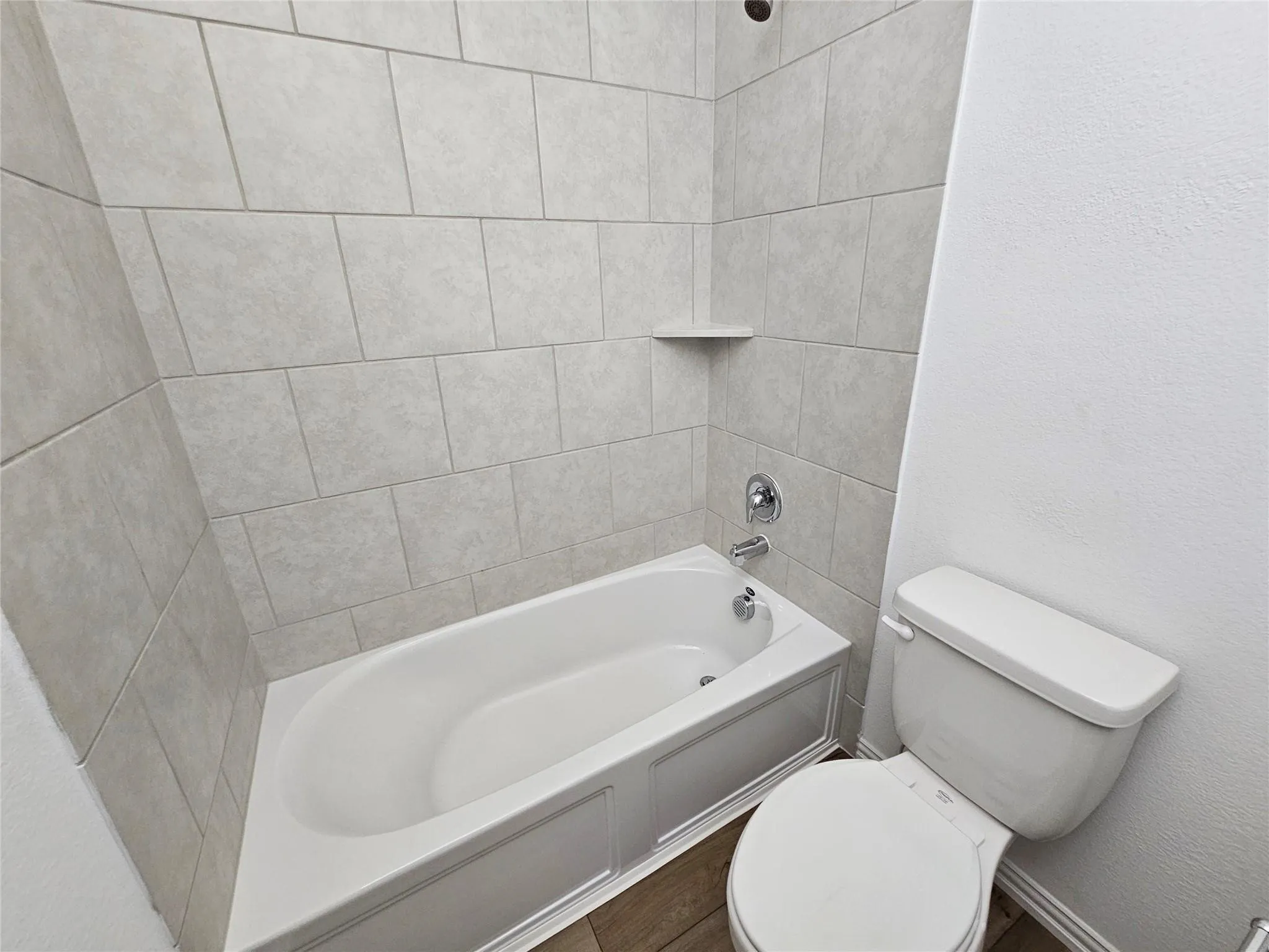 Bathtub with subway tile surround and integrated shelf