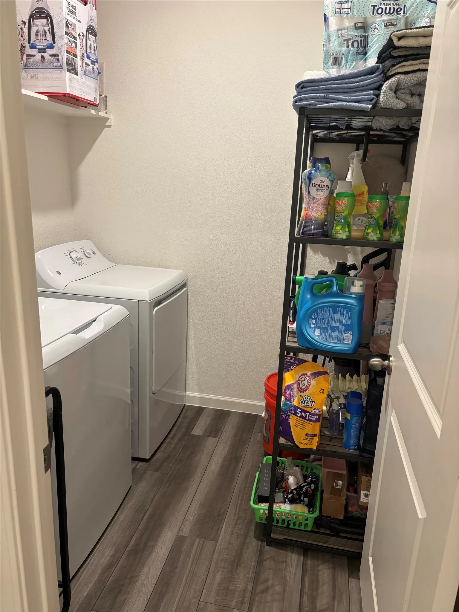 Dedicated utility space featuring wood-finish flooring and a wall-mounted shelf