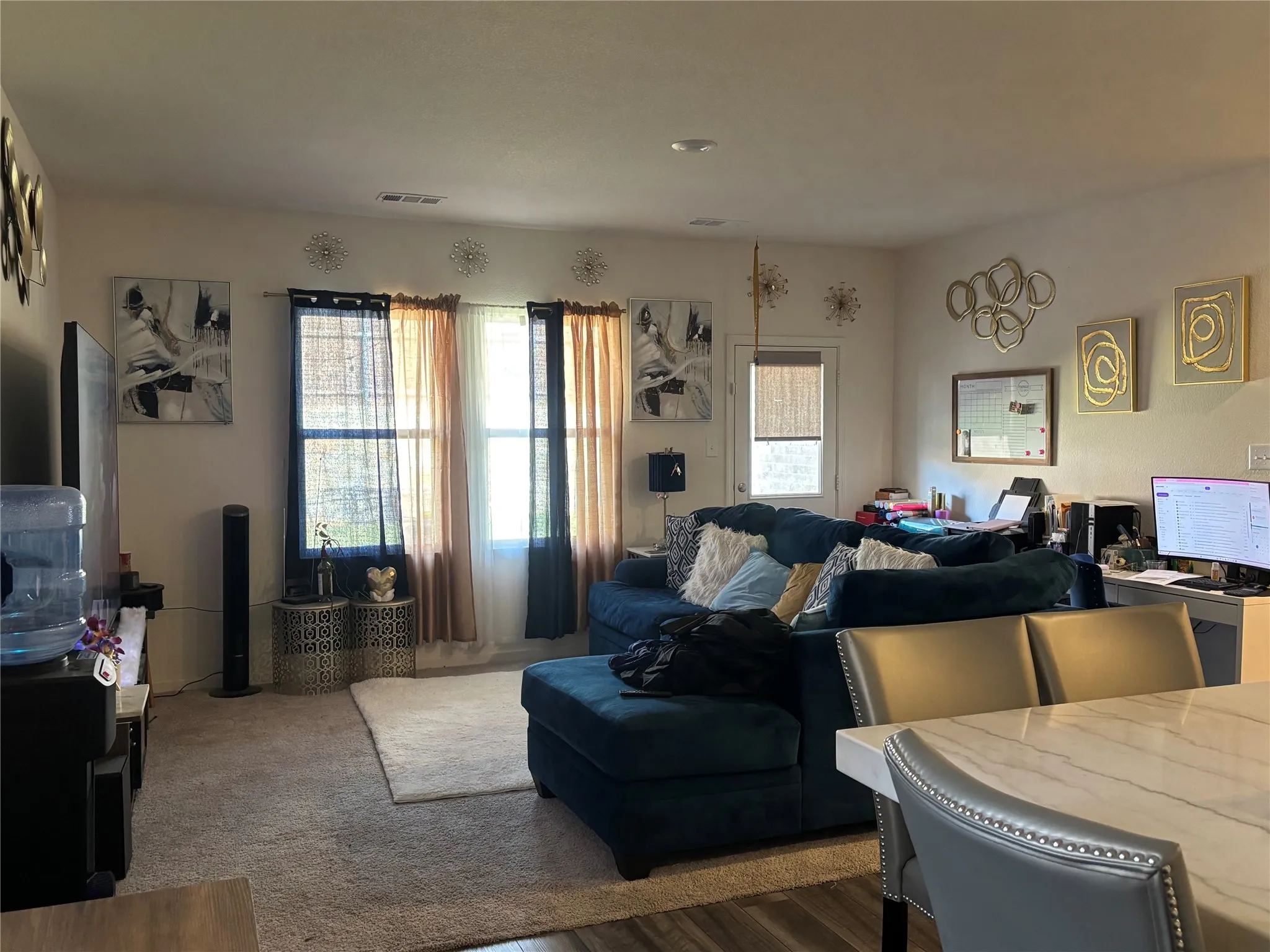 Living area featuring carpeted flooring, multiple windows, and a built-in desk area