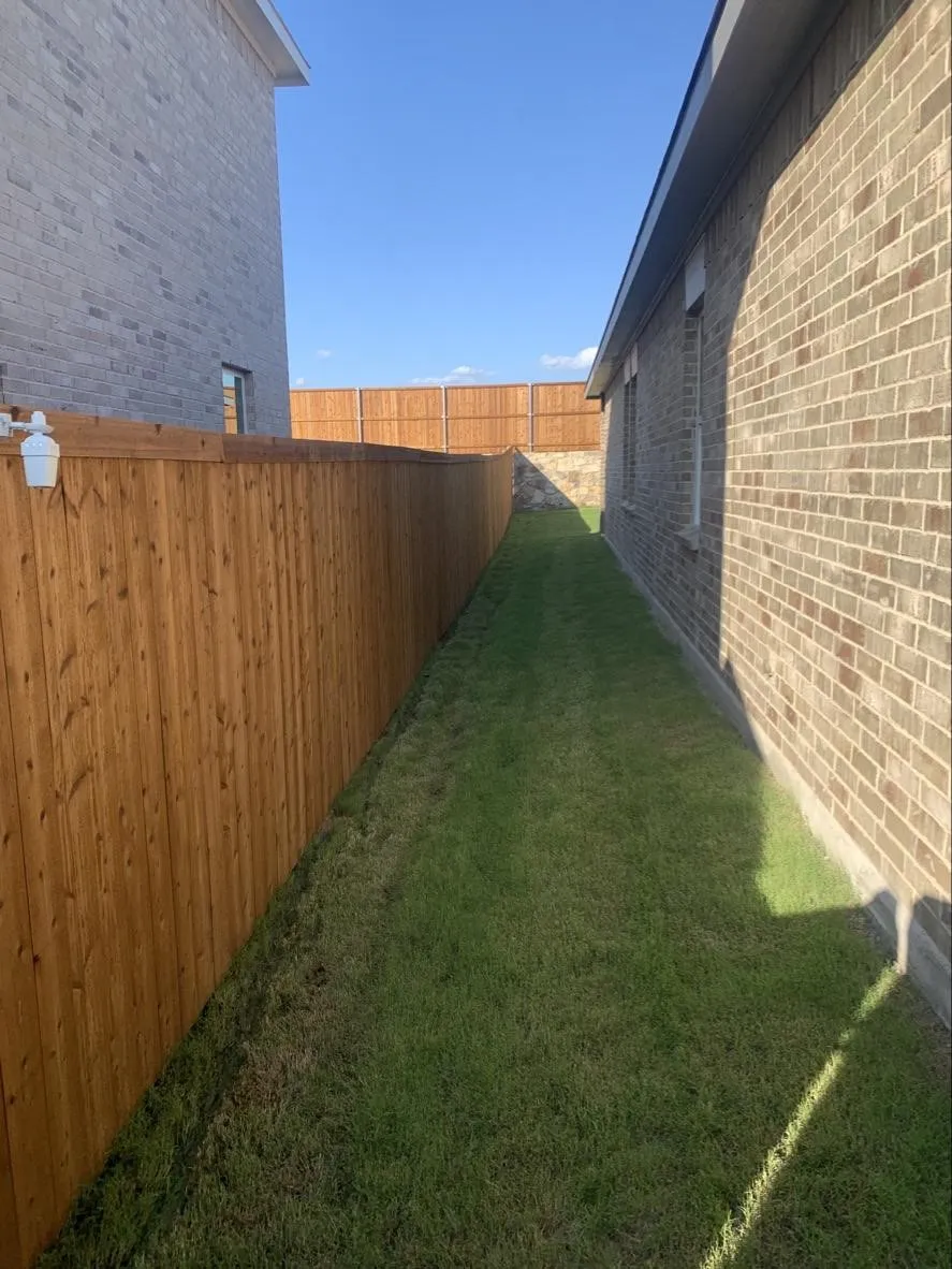 Brick exterior, natural wood fencing, and green lawn space
