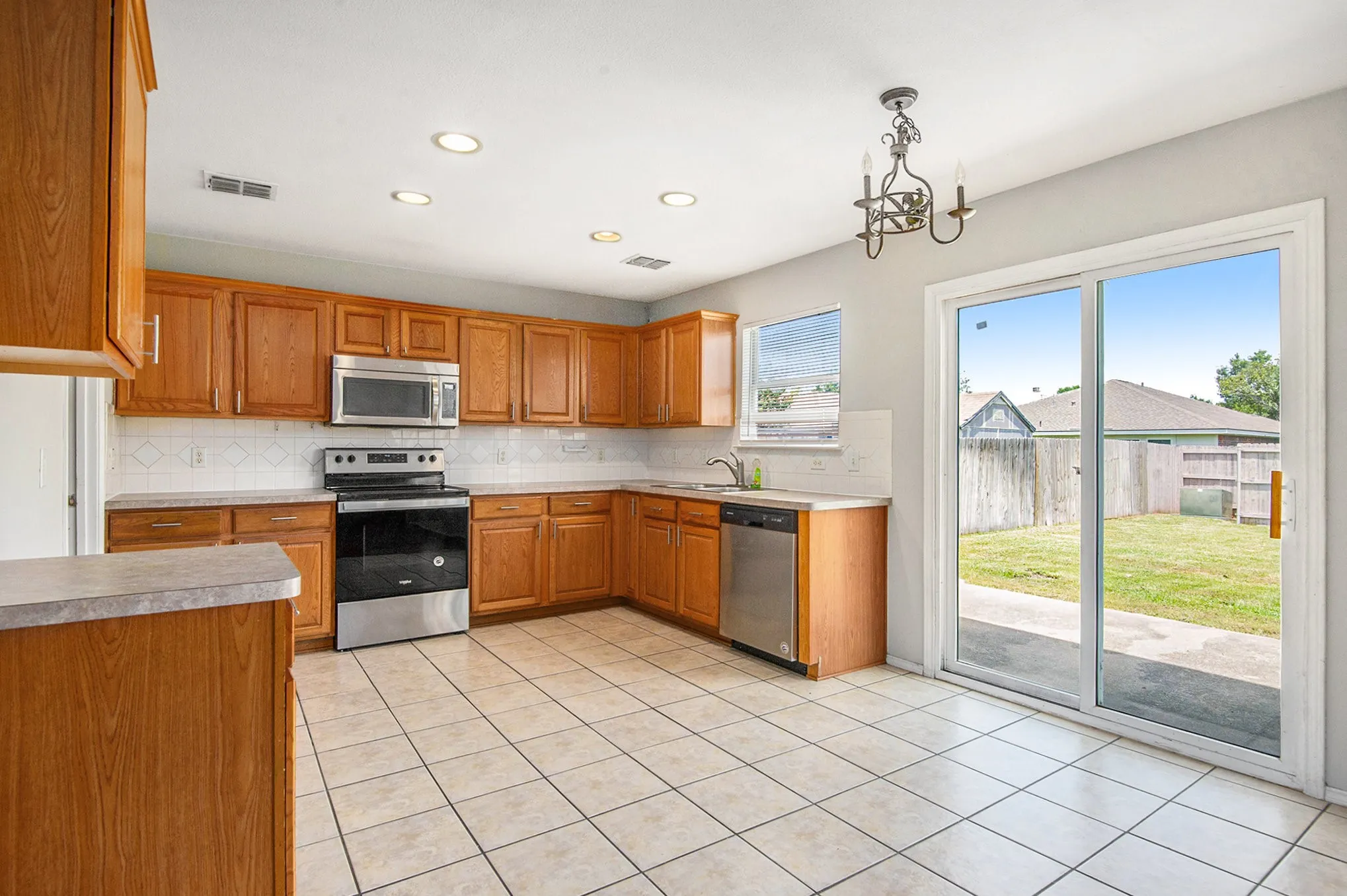 Kitchen with stainless steel appliances, decorative backsplash, light countertops, and recessed lighting