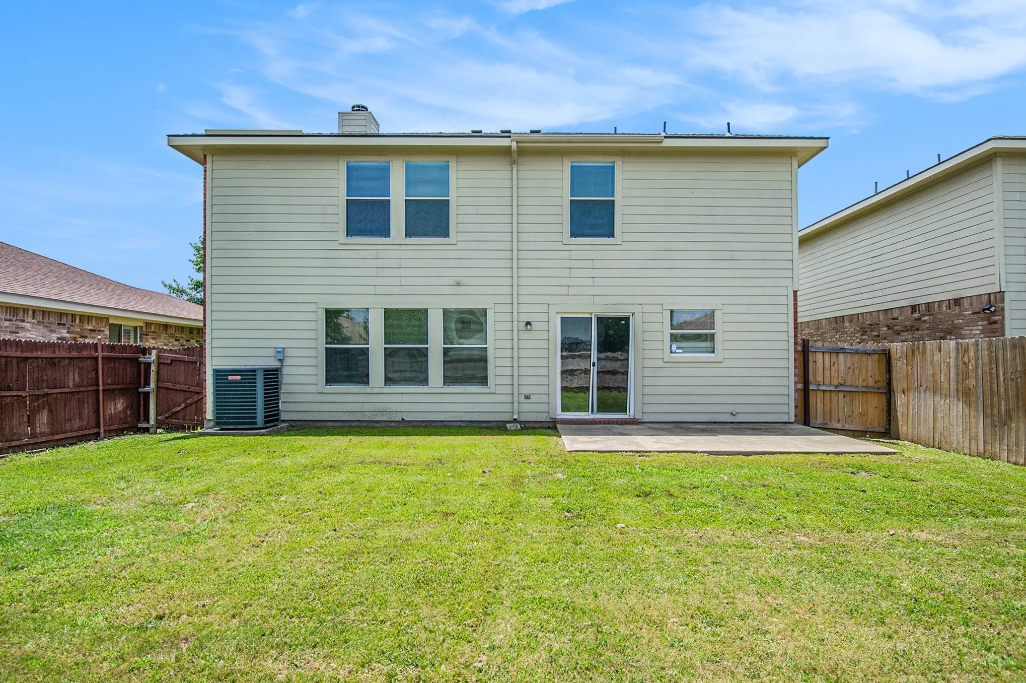 Rear view of property featuring a patio, a fenced backyard, and a chimney
