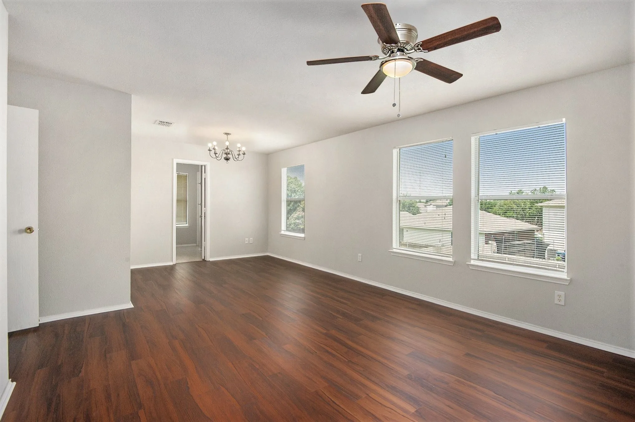 Unfurnished room with a chandelier, dark wood finished floors, and a ceiling fan