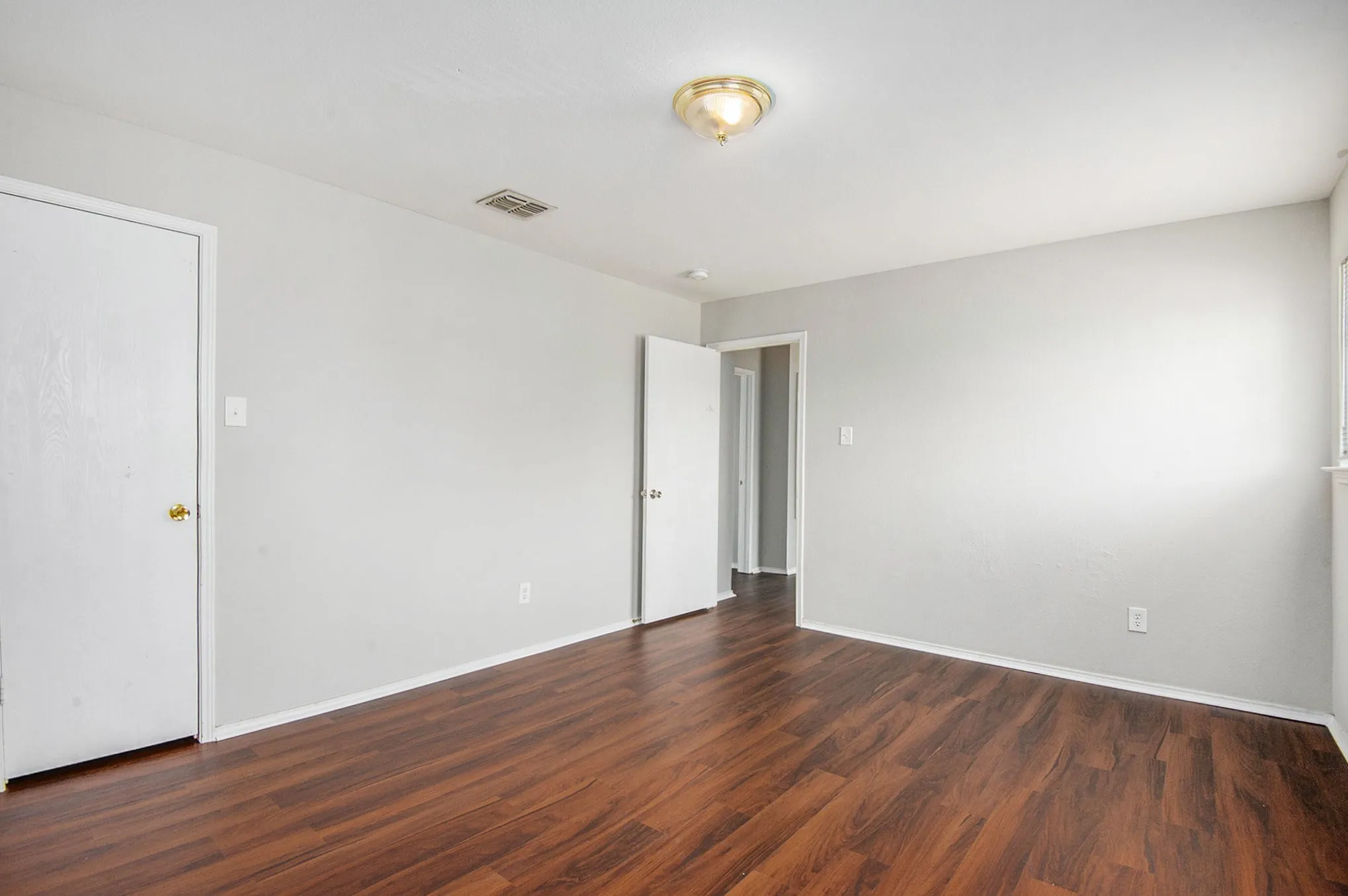 Unfurnished room featuring dark wood finished floors and baseboards