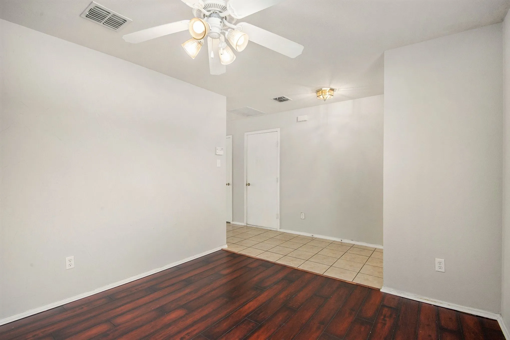 Spare room with wood finished floors and a ceiling fan
