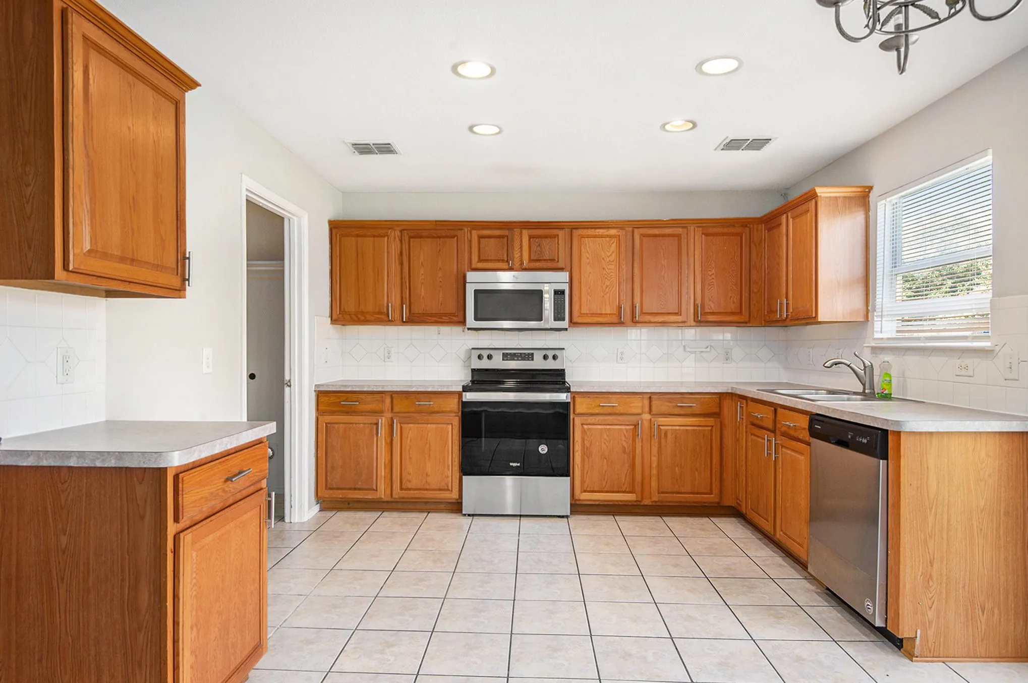 Kitchen with appliances with stainless steel finishes, tasteful backsplash, light countertops, and recessed lighting