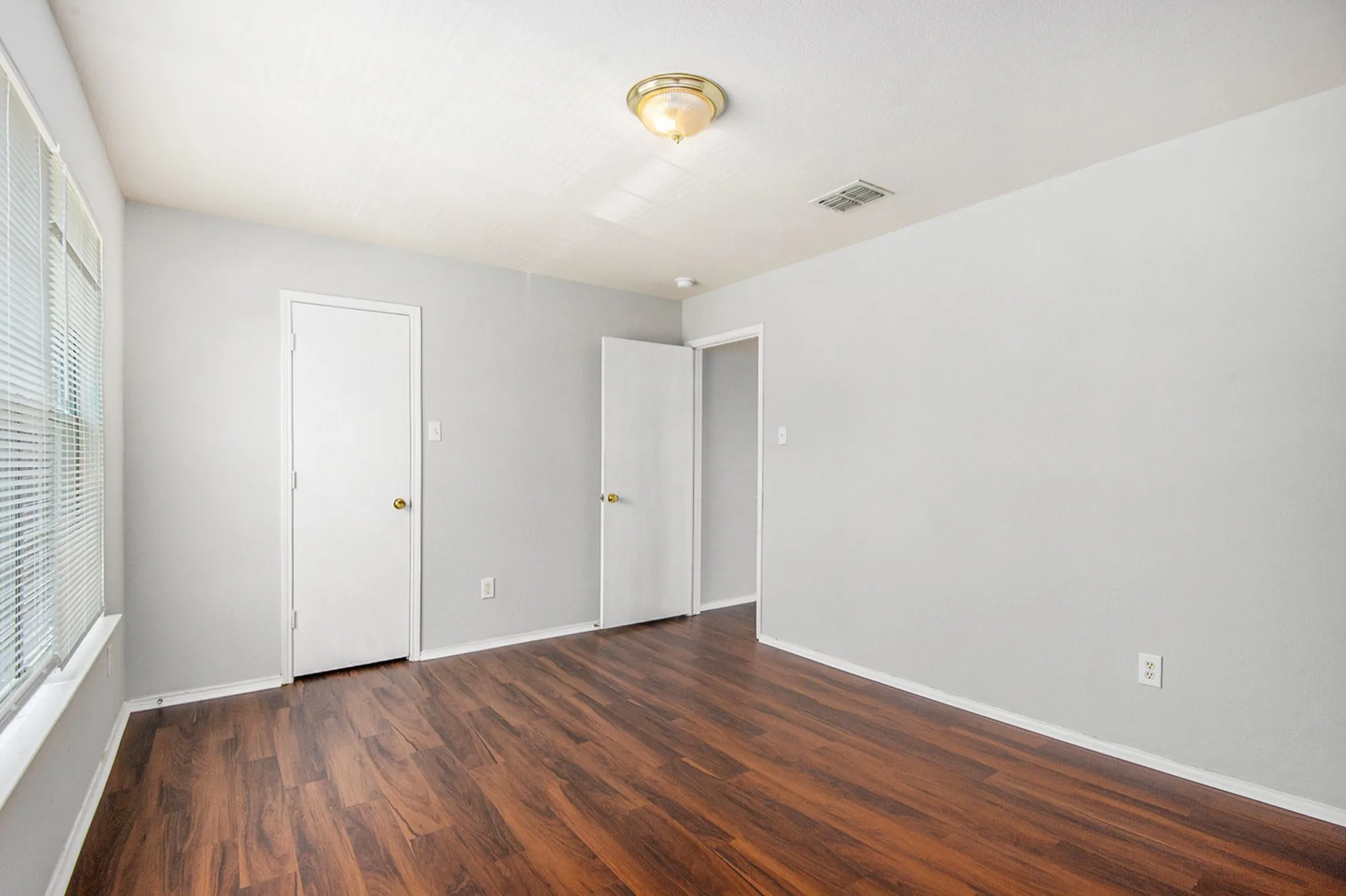 Unfurnished bedroom with wood finished floors and baseboards