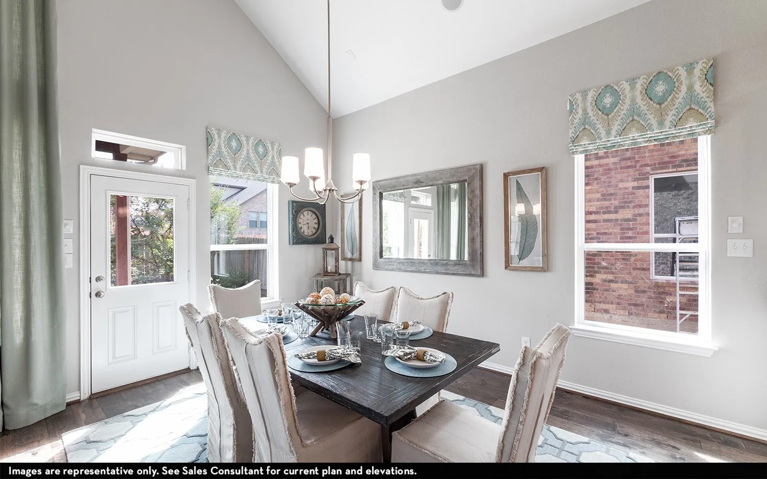 Vaulted ceilings with a chandelier, wood-finish flooring, a white door with a window pane, and a transom window