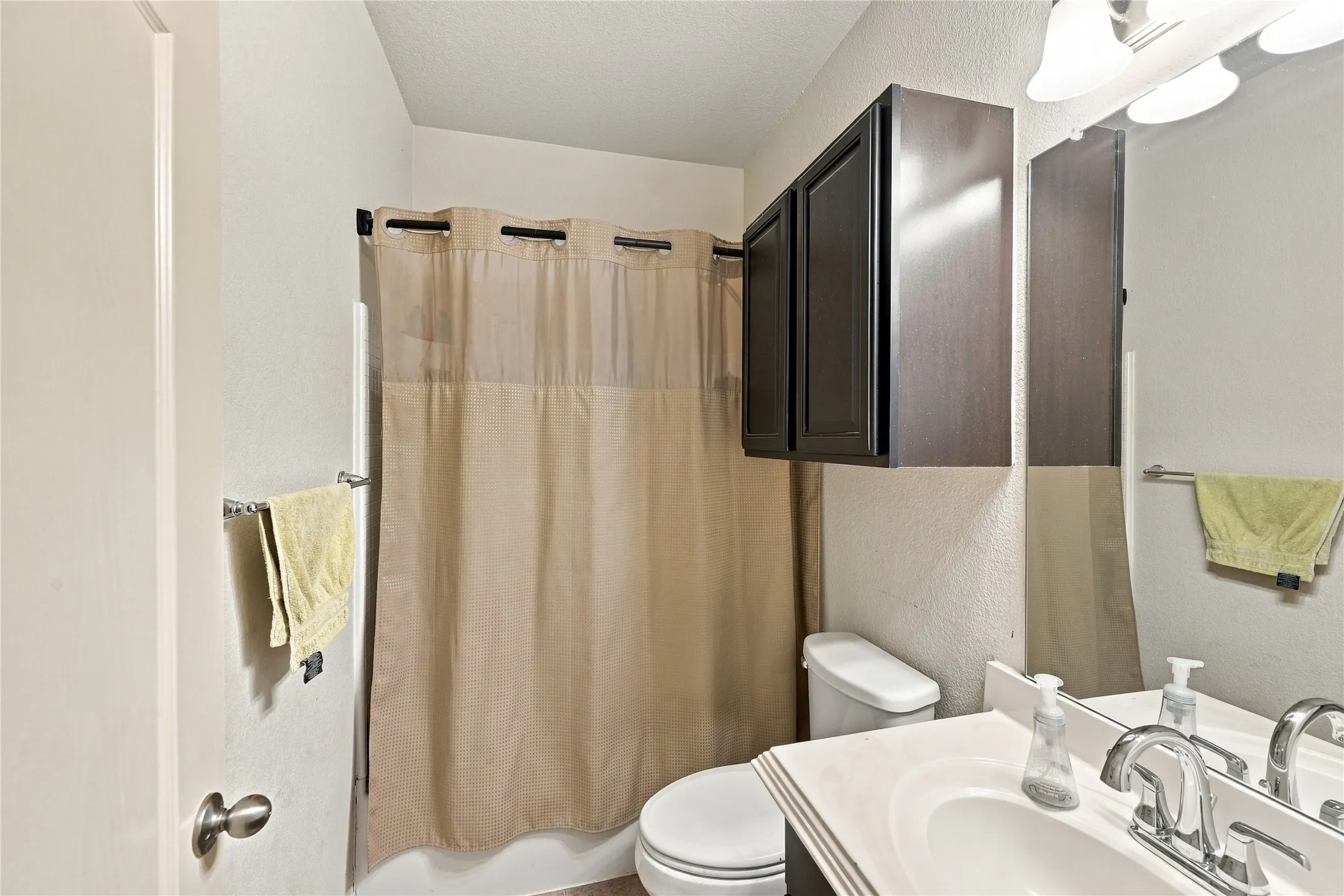 White vanity with integrated sink, chrome faucet, and mirrored medicine cabinet