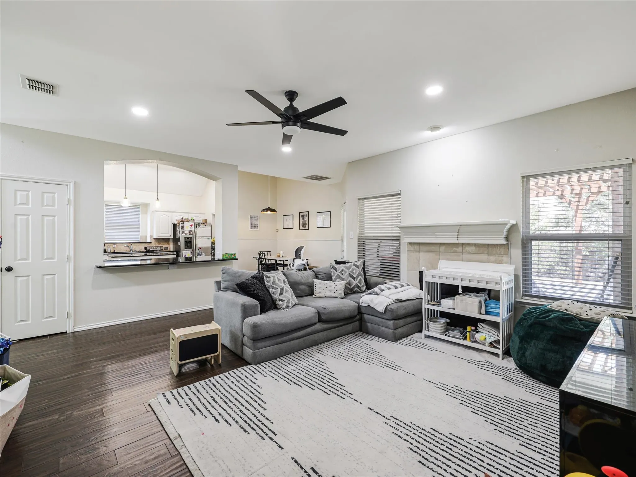 Spacious living area featuring wood-finish flooring, recessed lighting, and a ceiling fan