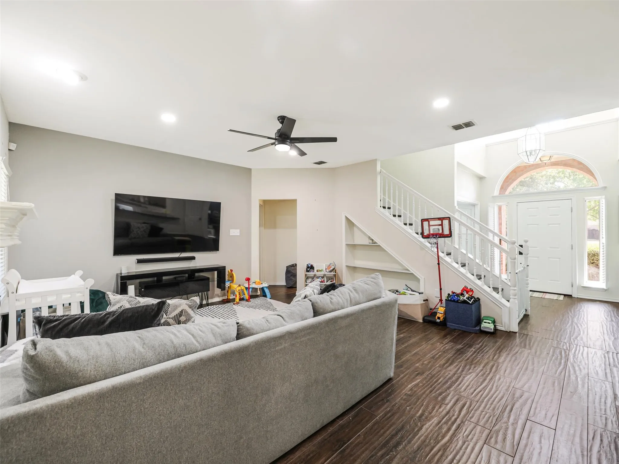 Wood-finish flooring, recessed lighting, and a white staircase with built-in shelving