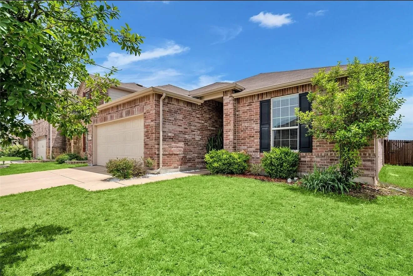 Brick exterior with a gabled roof and attached garage