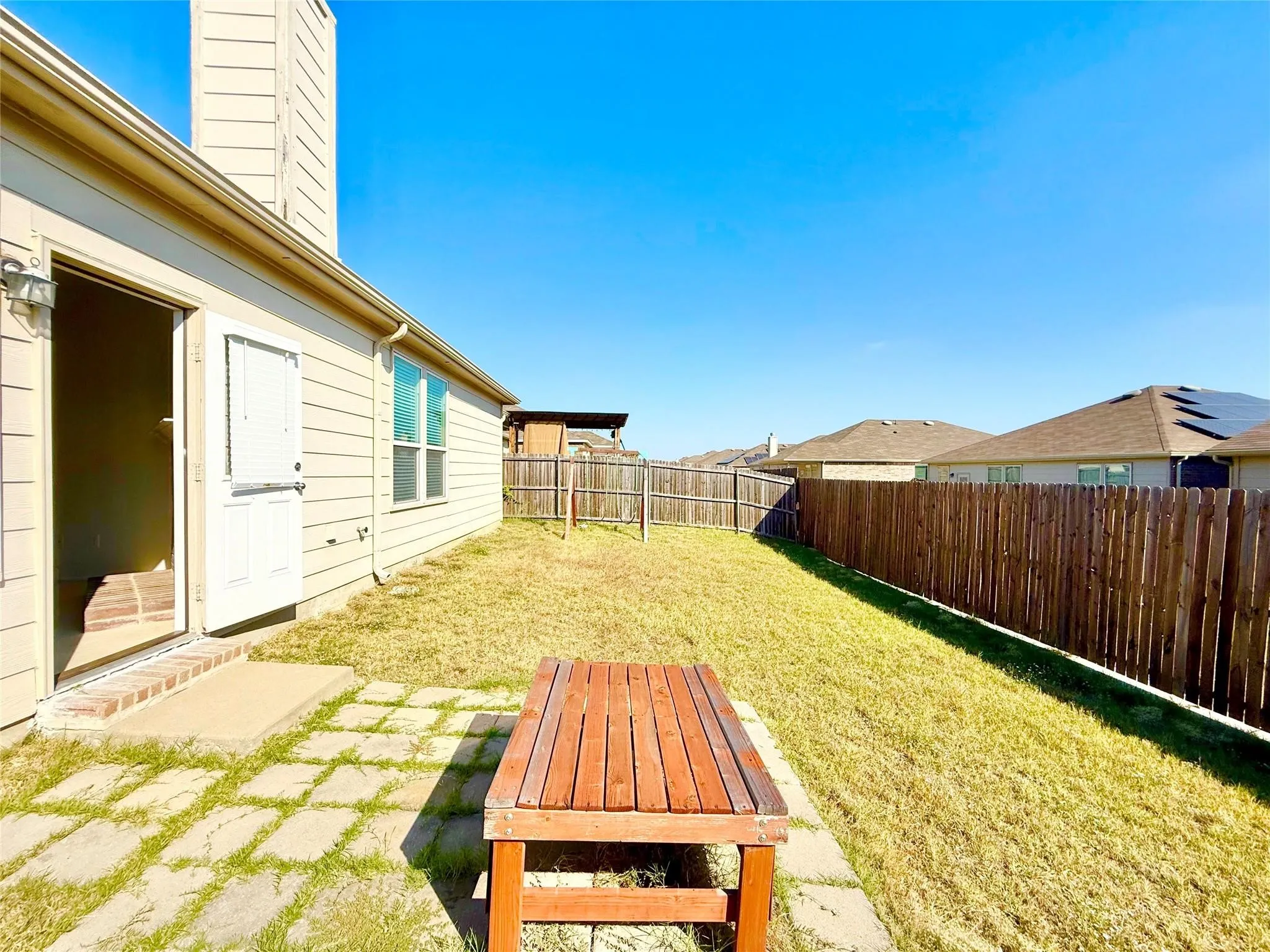 Private backyard with wood privacy fencing, a concrete patio, and a grass lawn