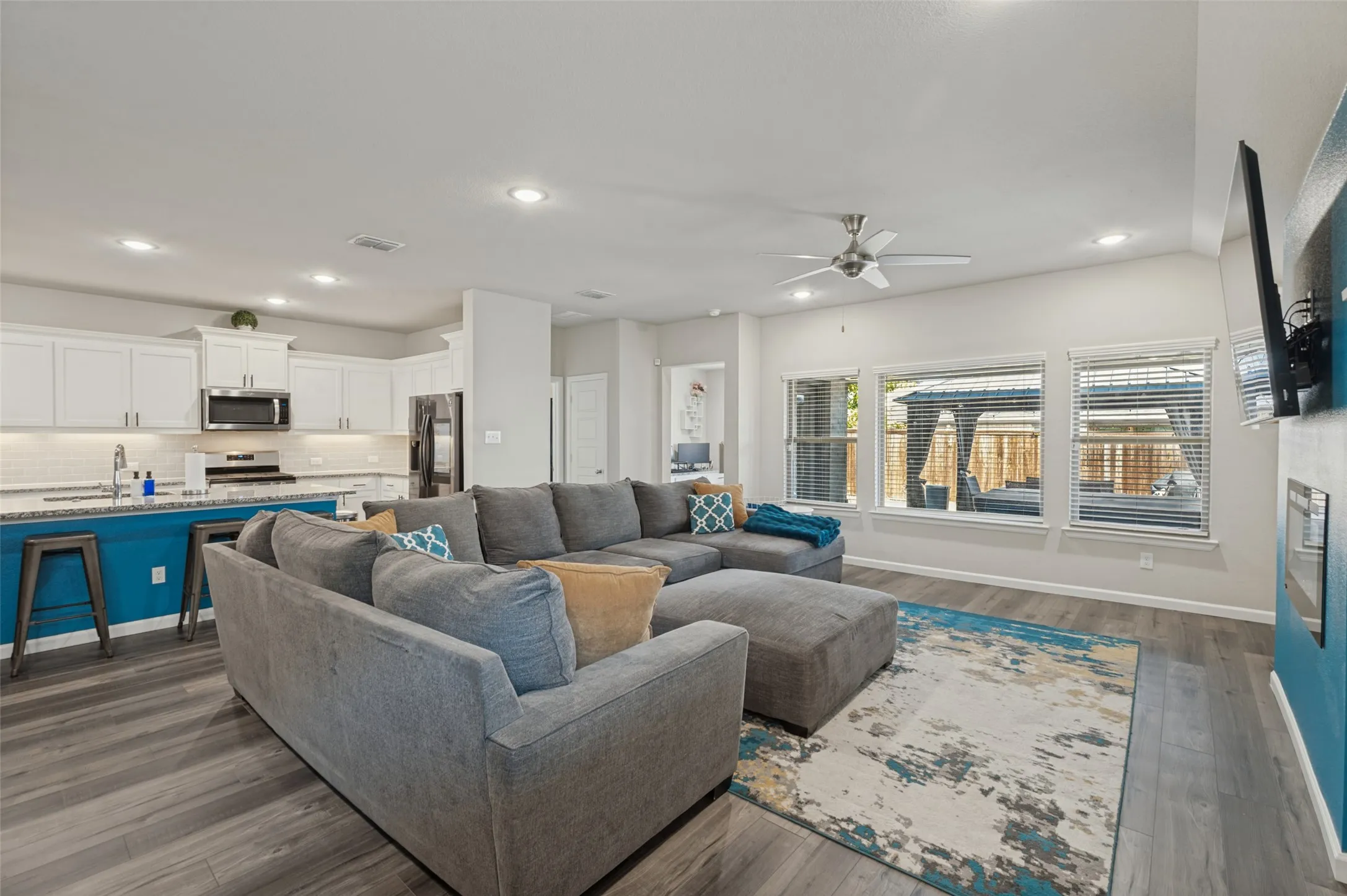Open-concept living area featuring wood-finish flooring, recessed lighting, and a ceiling fan