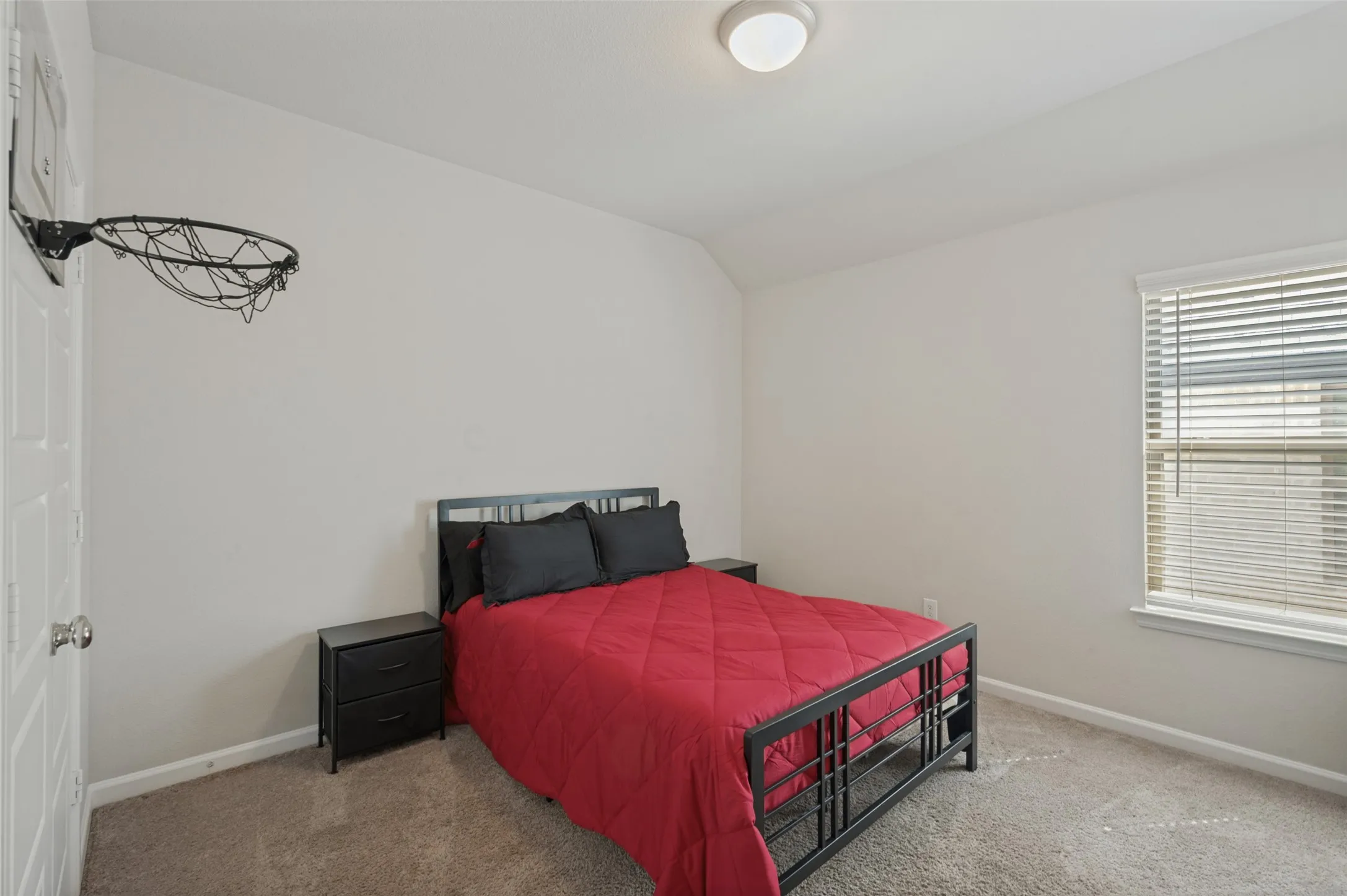 Carpeted room with a single window, white window blinds, and a flush mount ceiling light fixture