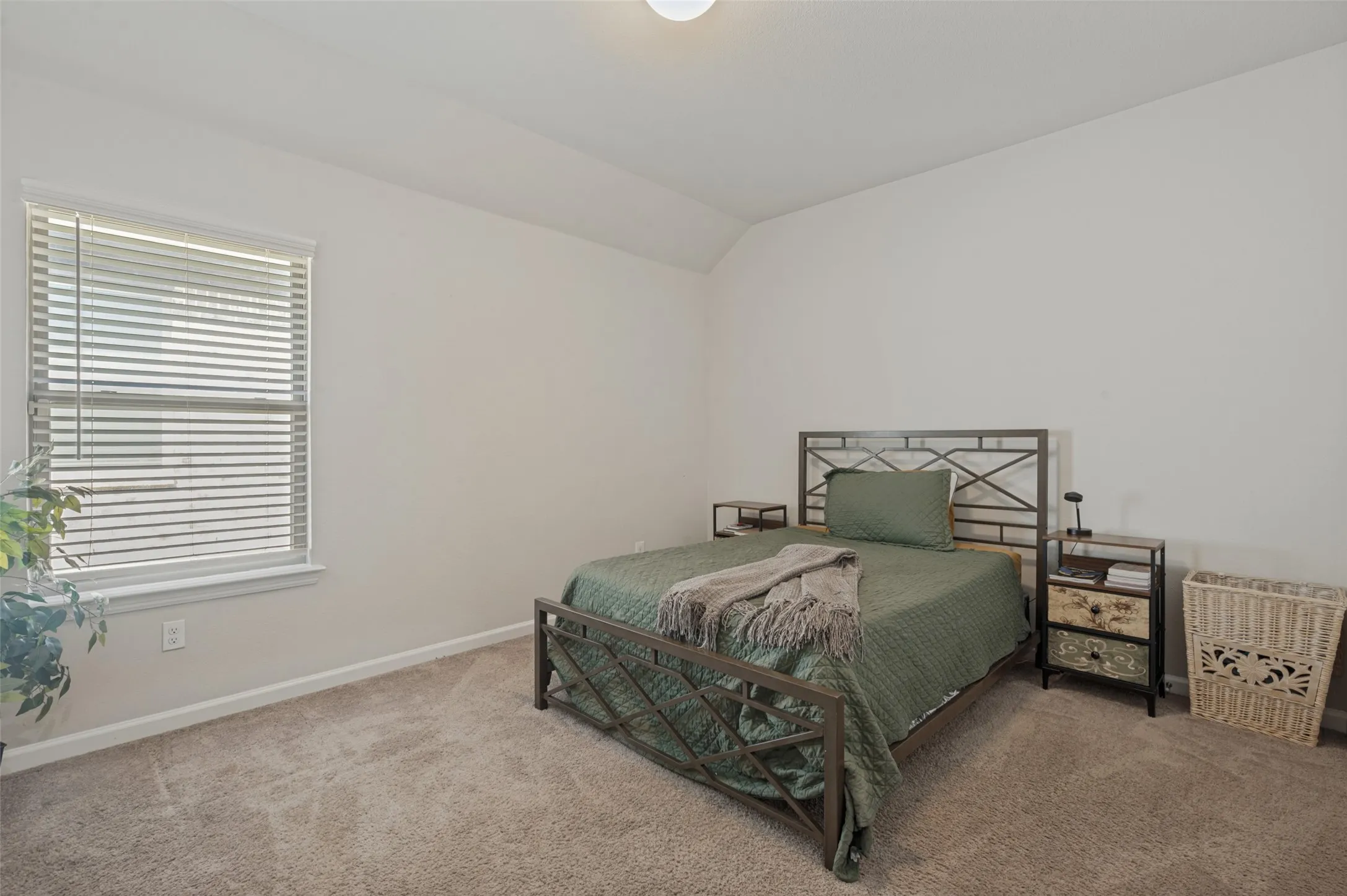 Neutral tone carpet flooring with white walls and a single window with blinds