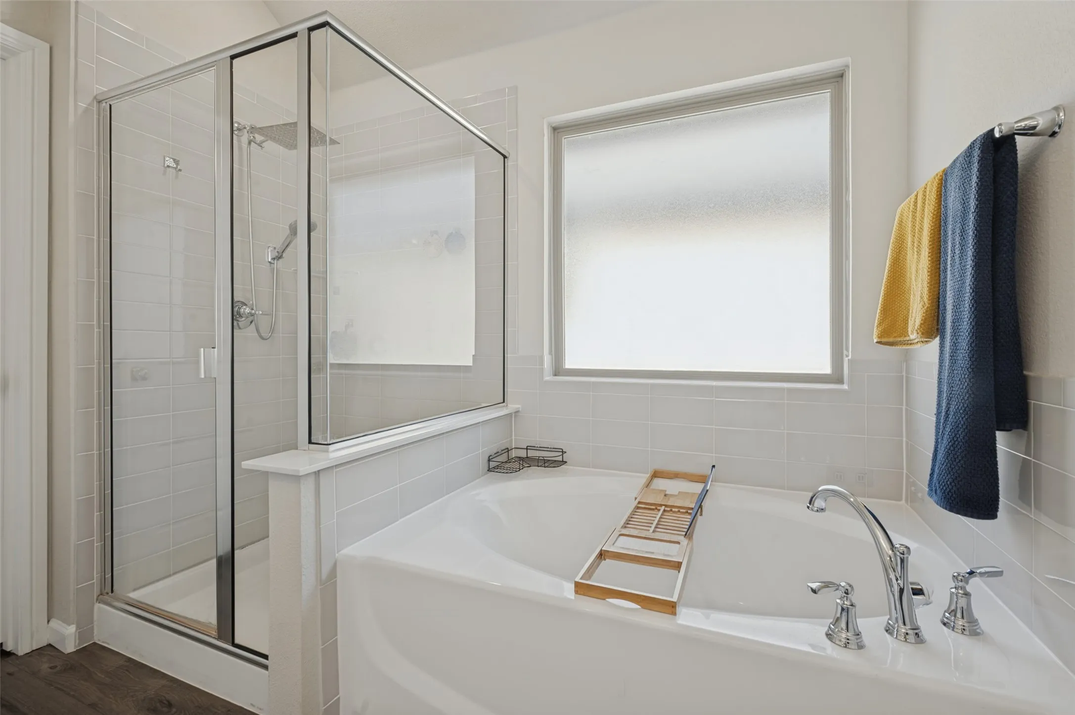 Glass-enclosed shower with a separate soaking tub