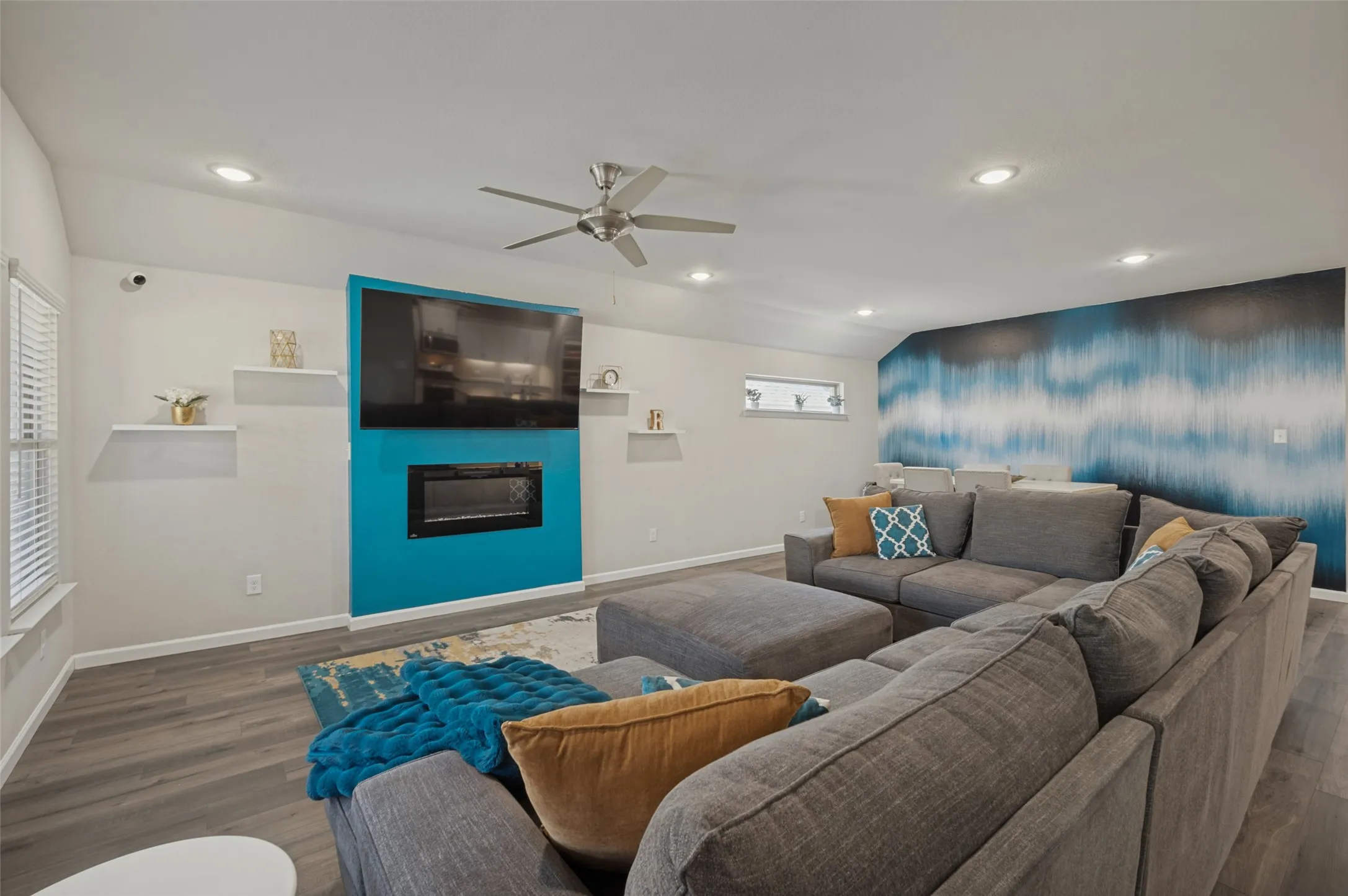 Vaulted ceiling, recessed lighting, wood-finish flooring, built-in fireplace, and a ceiling fan