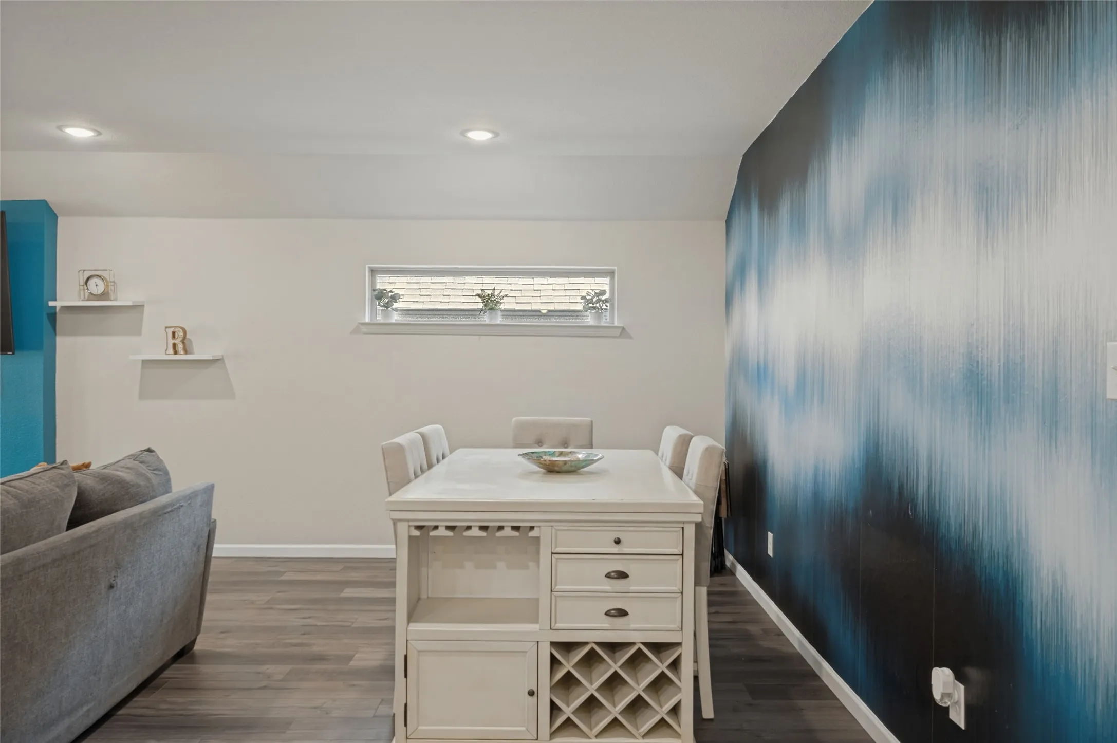 Wood-finish flooring throughout, recessed lighting, and a horizontal window
