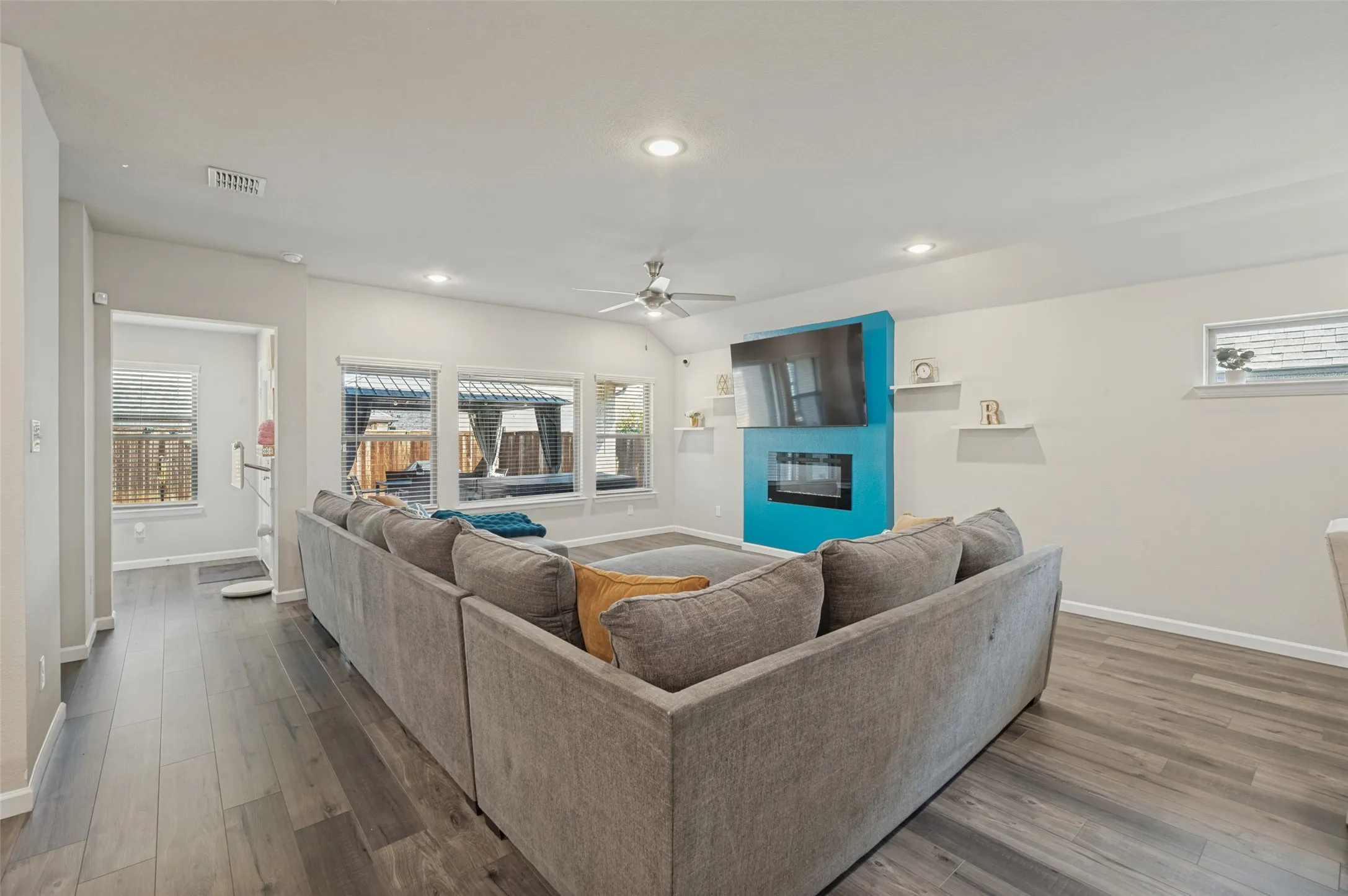 Spacious living area featuring wood-finish flooring, recessed lighting, and a ceiling fan
