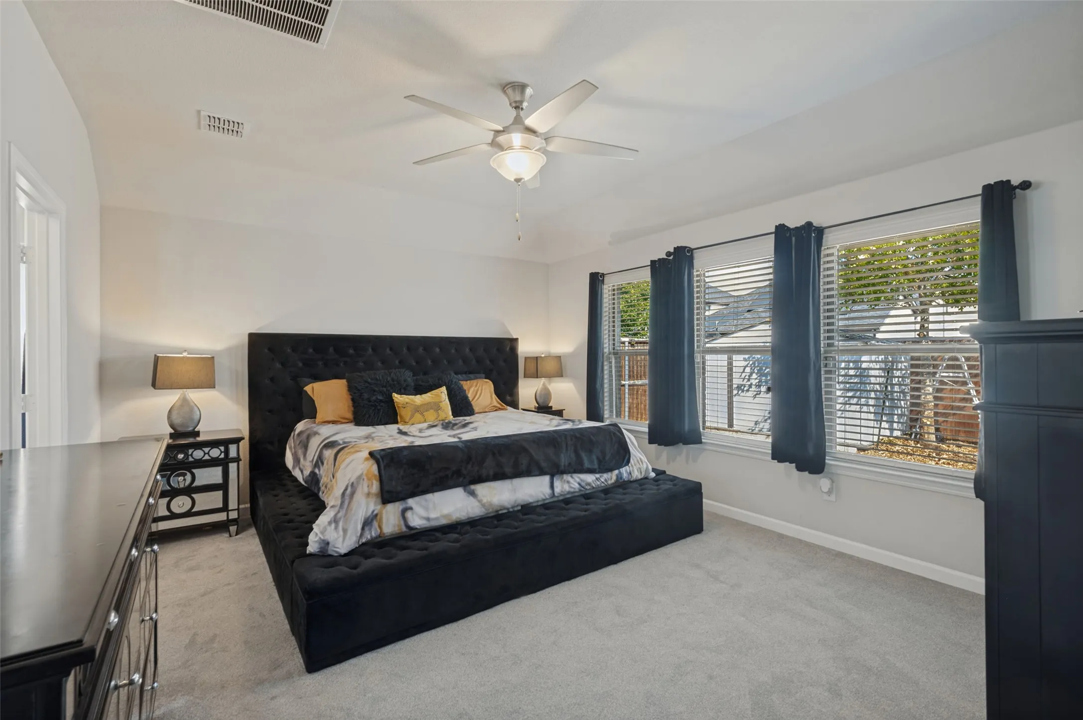 Recessed lighting, ceiling fan with integrated lighting, multiple windows, carpeted flooring, and neutral wall paint