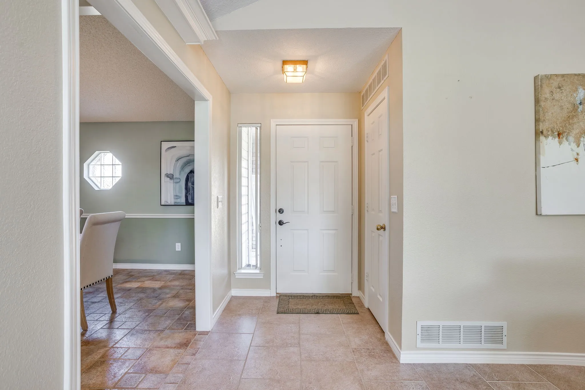 Entryway with ceramic tile flooring, a paneled door, and a vertical sidelight window