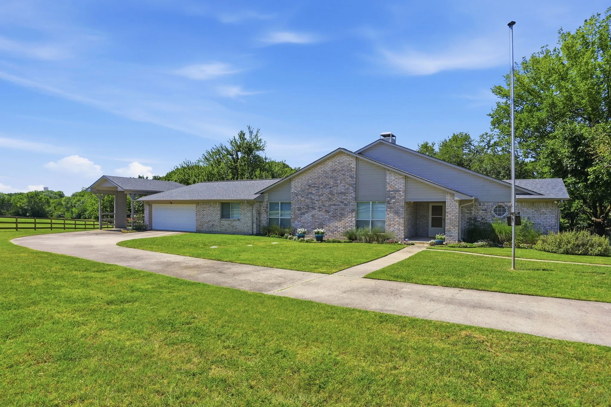 Brick exterior residence with an attached two-car garage, separate RV carport, and a detached tandum 3 car garage
