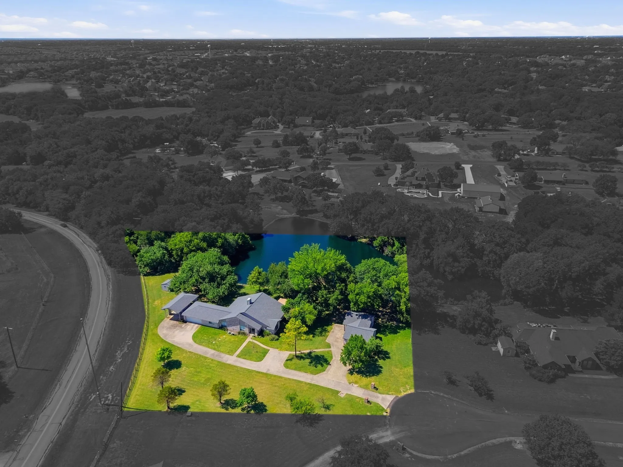 Expansive property featuring a private pond, mature trees, and a spacious green lawn