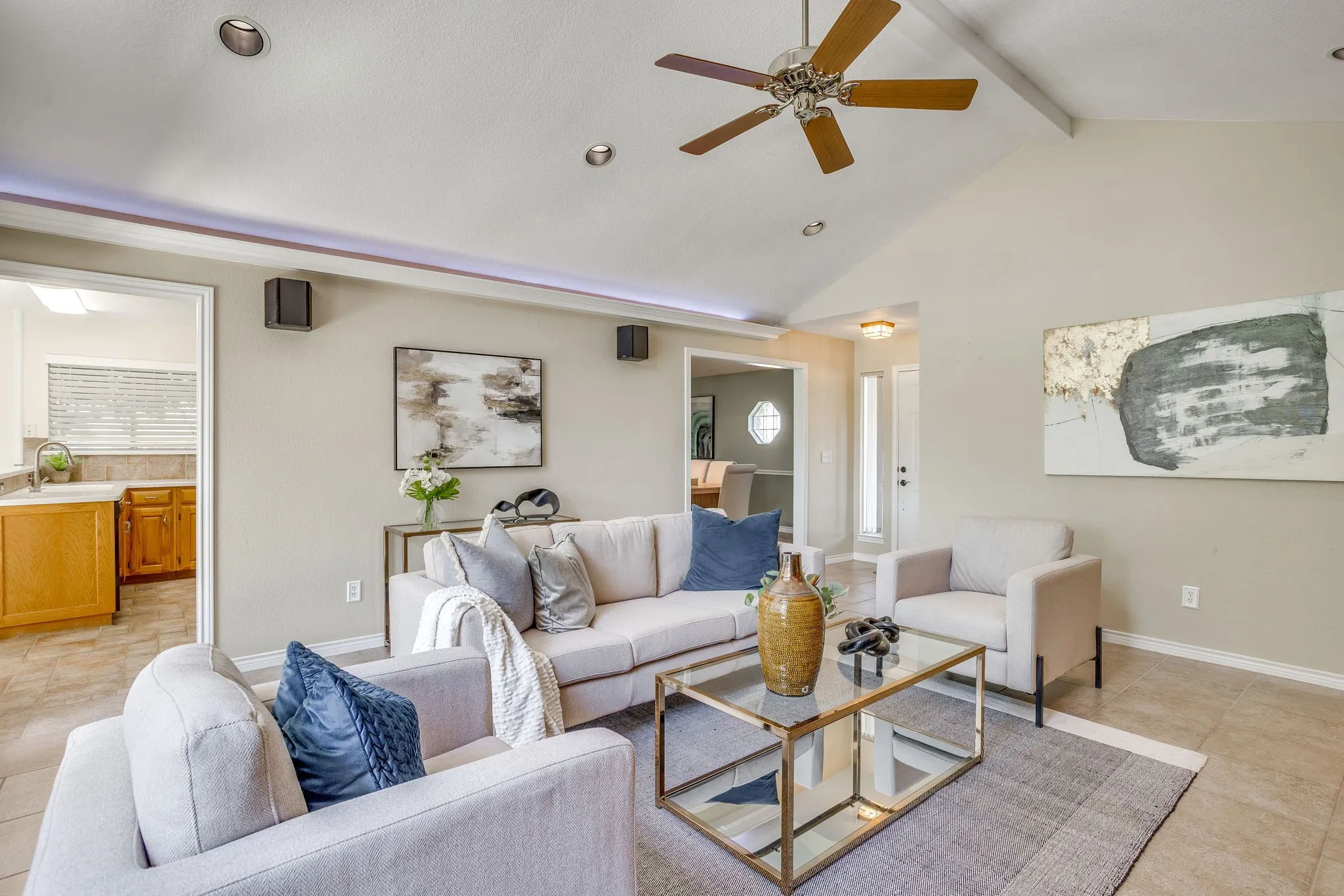 Vaulted ceiling with a ceiling fan, recessed lighting, tile flooring, and a framed doorway