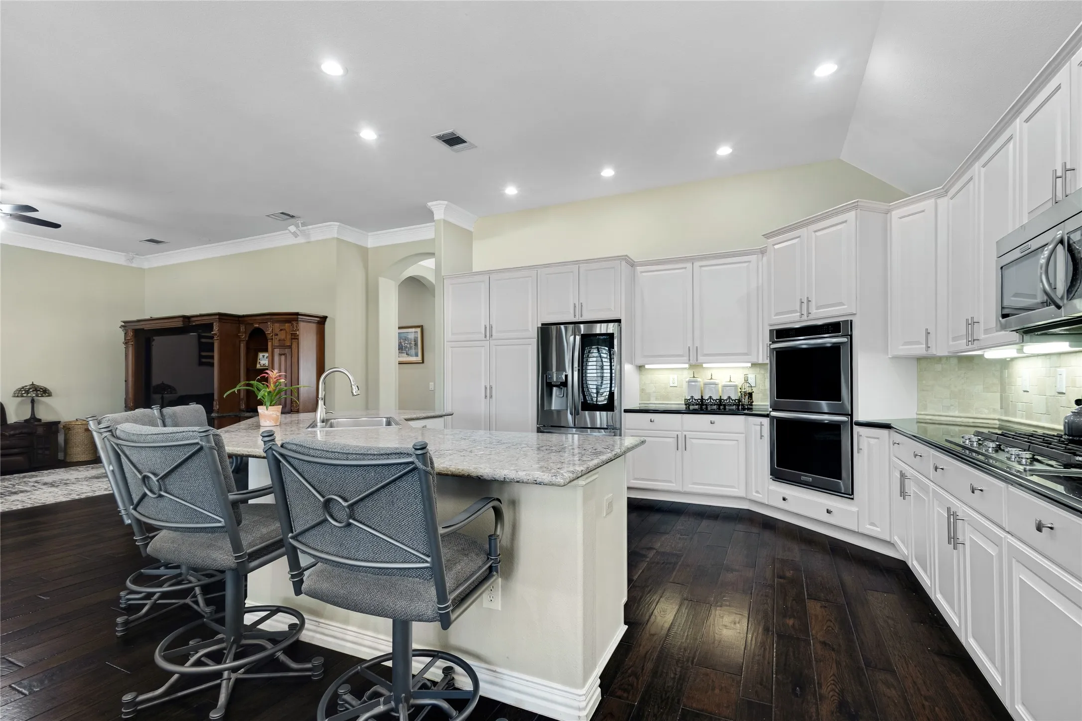 Kitchen featuring white cabinetry, dark wood-finish flooring, recessed lighting, and stainless steel appliances