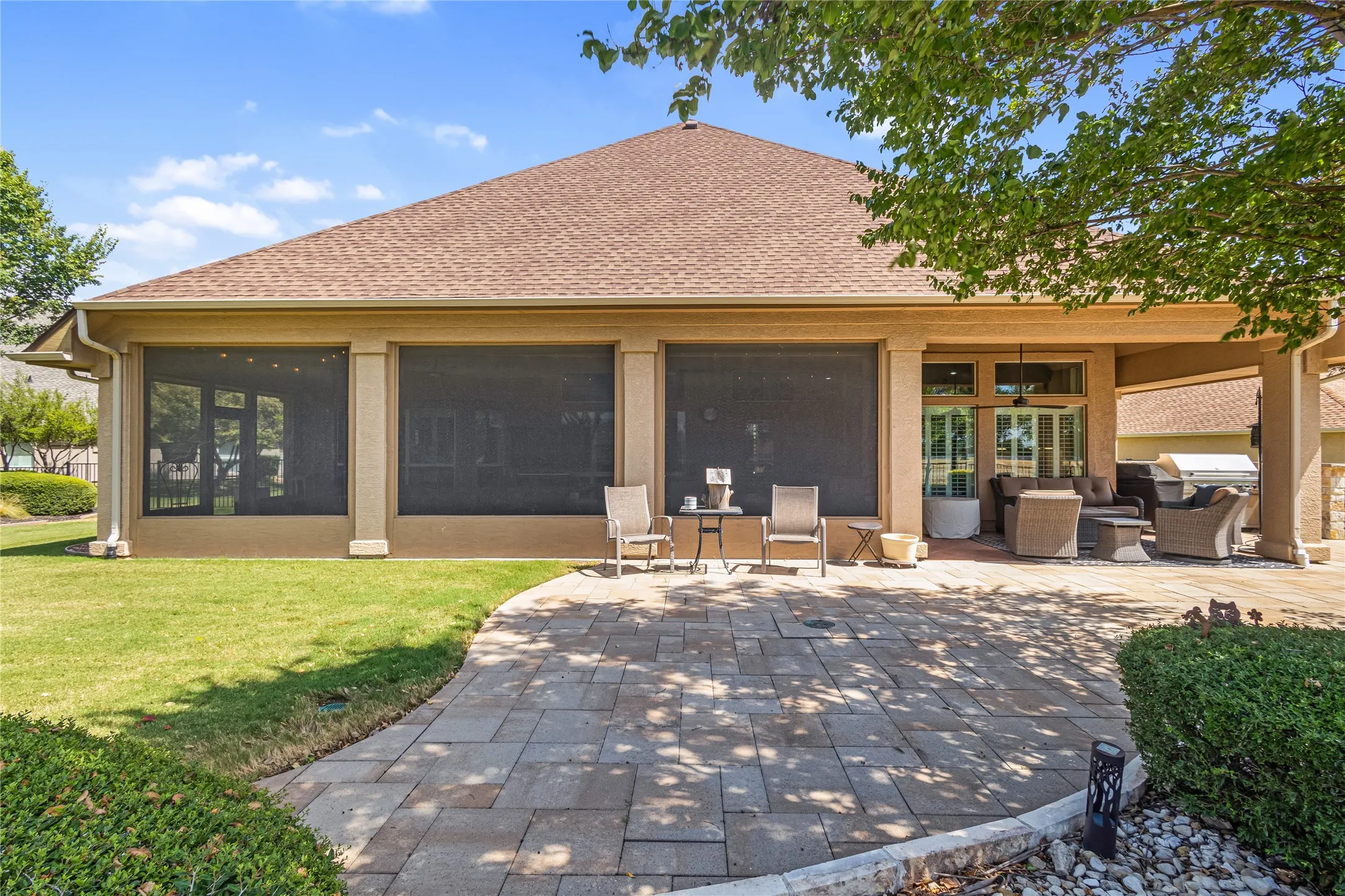 Expansive paver patio with a screened-in porch and covered outdoor living space