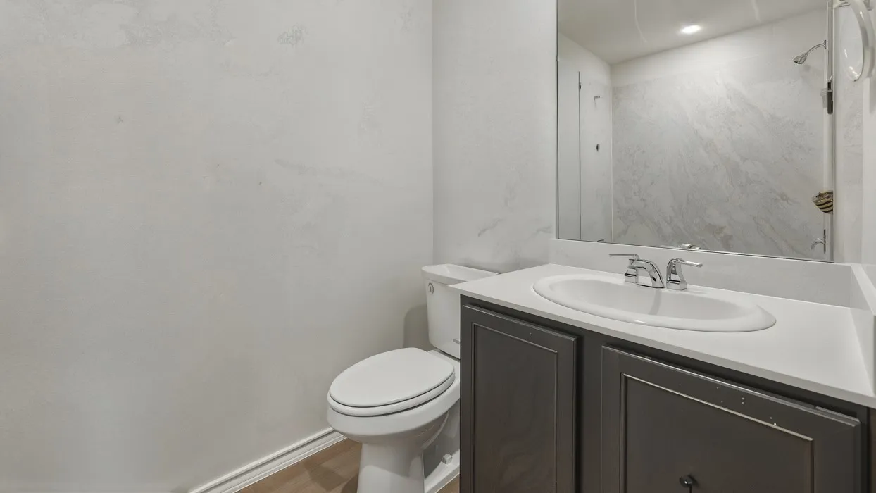 Bathroom featuring a dark wood-finish vanity with an integrated sink, polished chrome faucet, and a large wall-mounted mirror