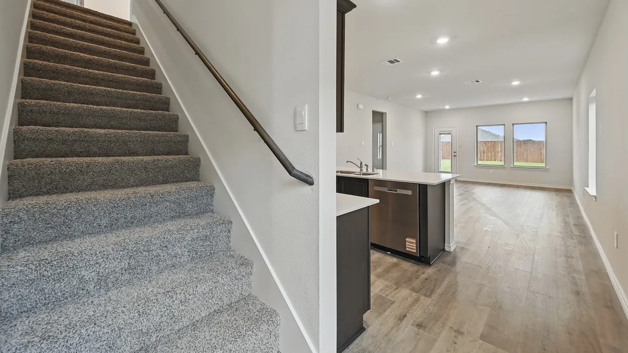 Open-concept living space featuring wood-finish flooring, recessed lighting, and ample natural light from multiple windows