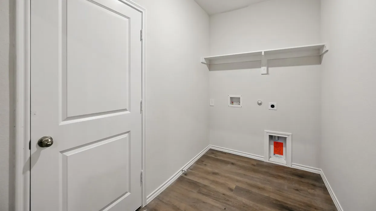 Utility space featuring wood-finish flooring, white painted walls, and a built-in white shelf