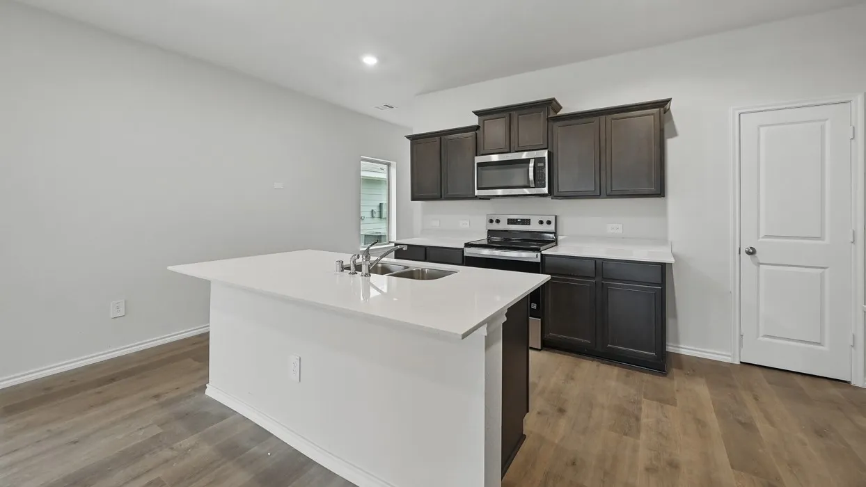 Modern kitchen featuring an island with a stainless steel sink and a gooseneck faucet