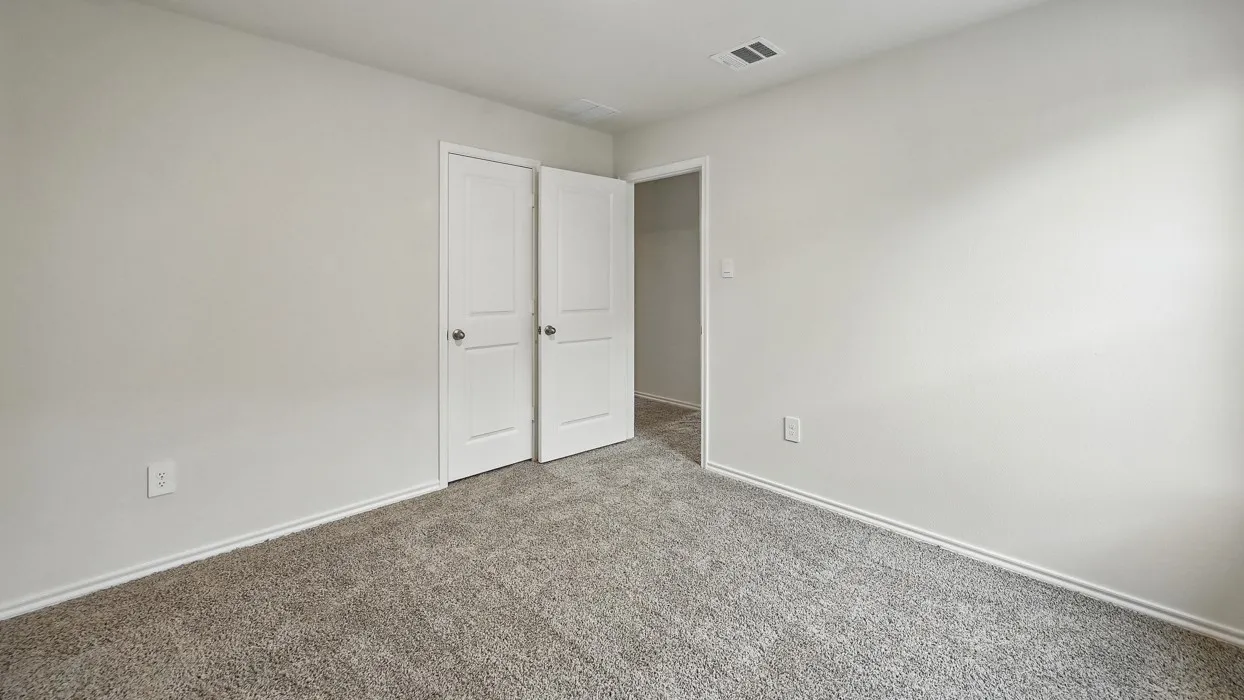 Carpeted room featuring light gray walls, white baseboards, and two-panel interior doors