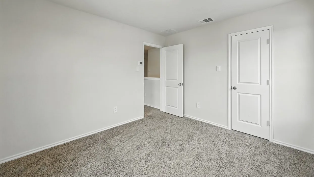 Neutral-toned room with plush carpeting and crisp white baseboards