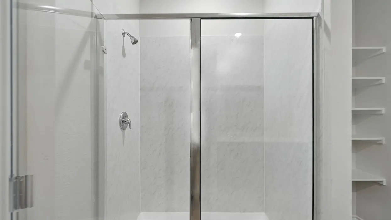 Shower enclosure featuring a sliding glass door and polished chrome fixtures