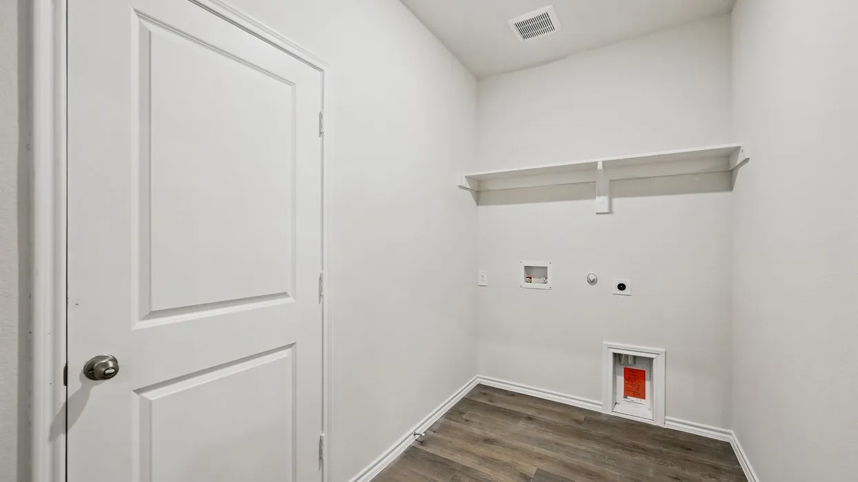 Utility area featuring wood-finish flooring, white walls, and a built-in shelf