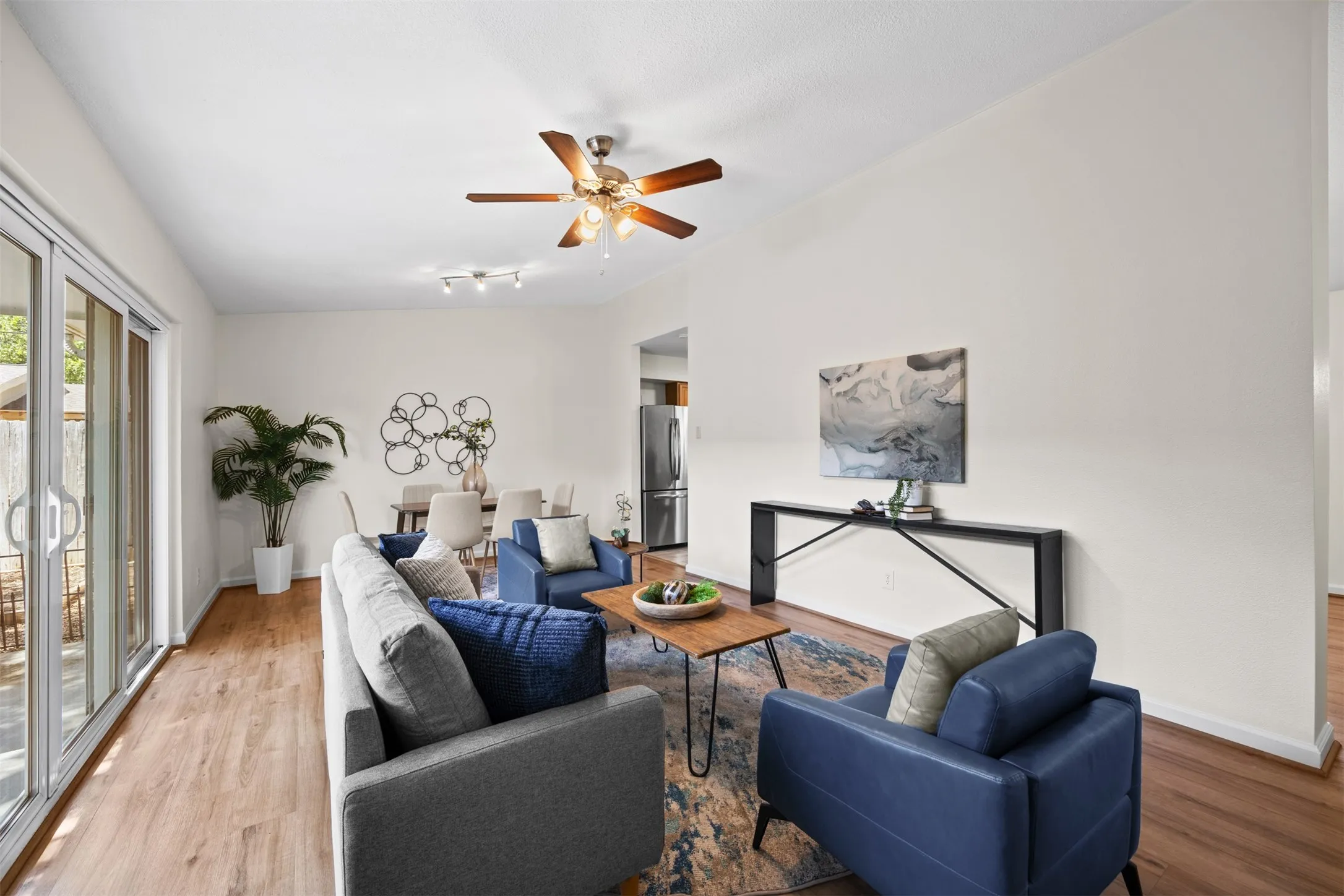 Vaulted ceilings, wood-finish flooring, ceiling fan, and sliding glass doors