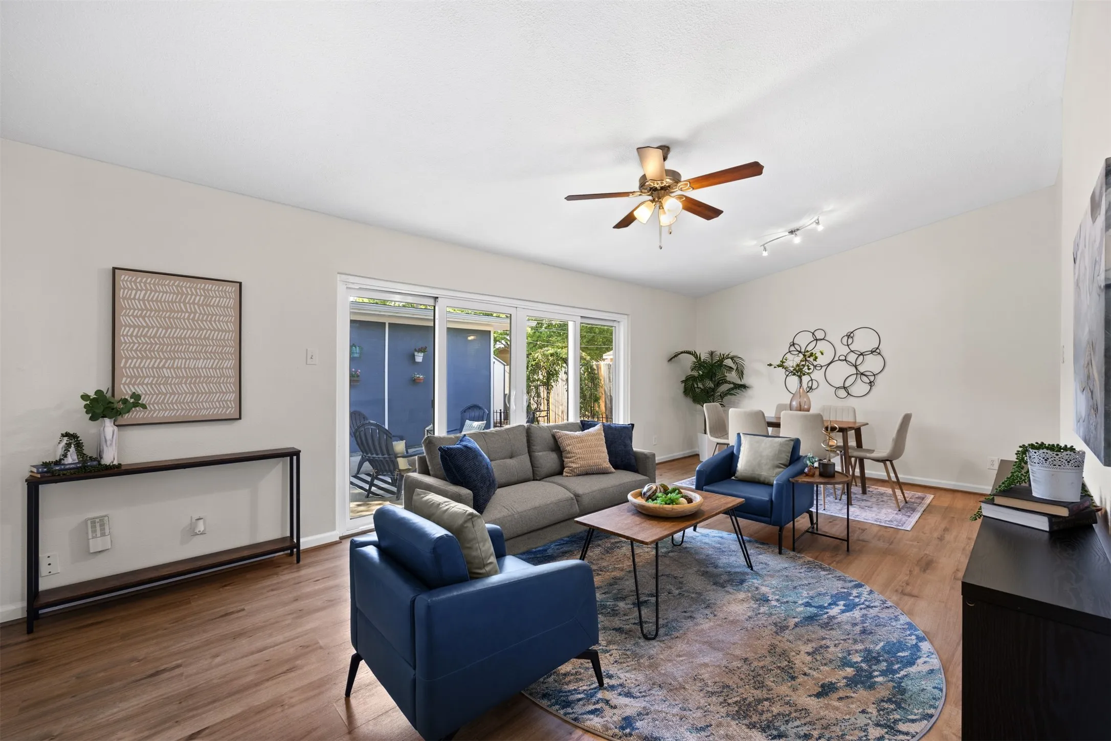 Wood-finish flooring throughout, vaulted ceiling, and a ceiling fan with integrated lighting