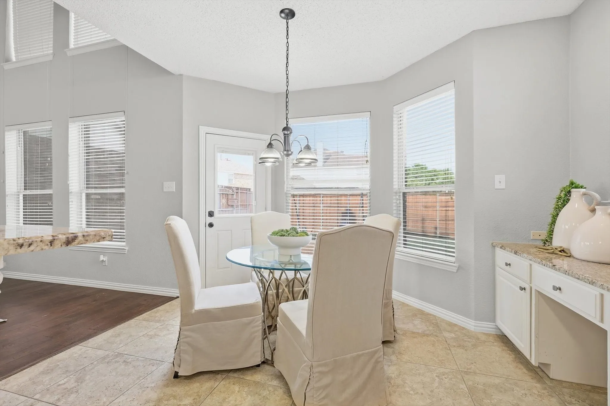 Tray ceiling with recessed lighting, tile flooring, built-in cabinetry, granite countertop, and multiple windows with blinds