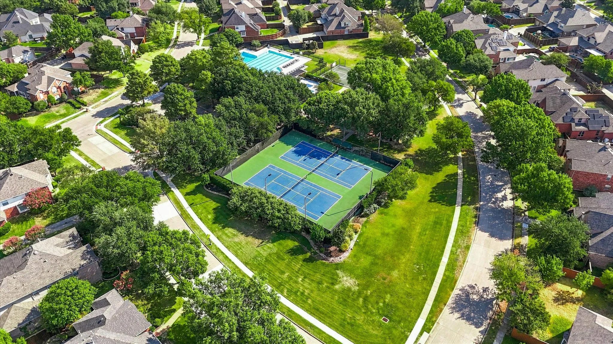 Community tennis courts, swimming pool, and park area with mature landscaping