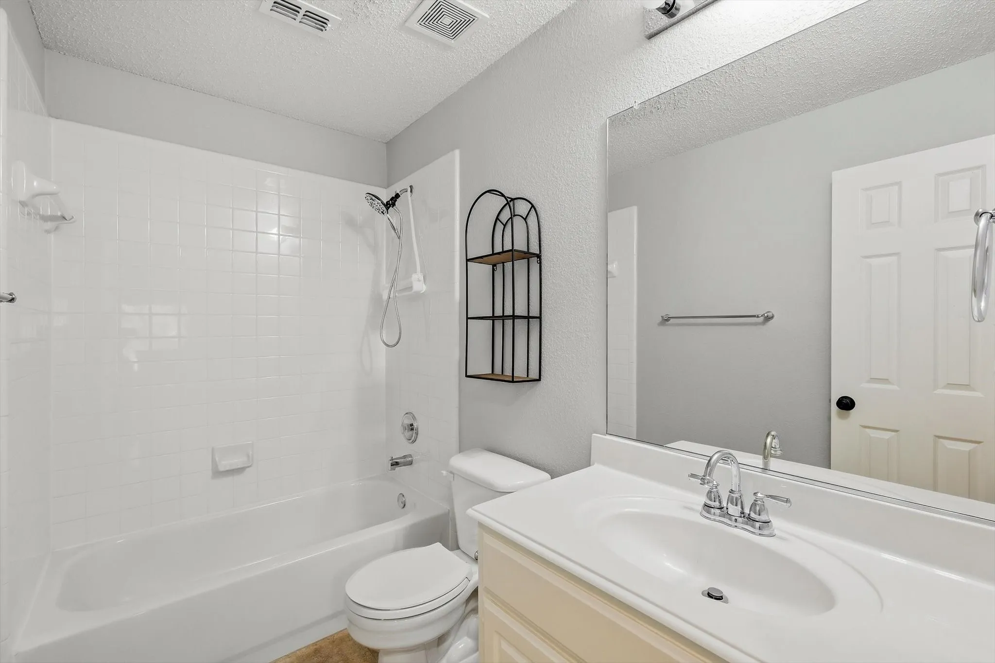 Built-in vanity with integrated sink, chrome faucet, and expansive mirror