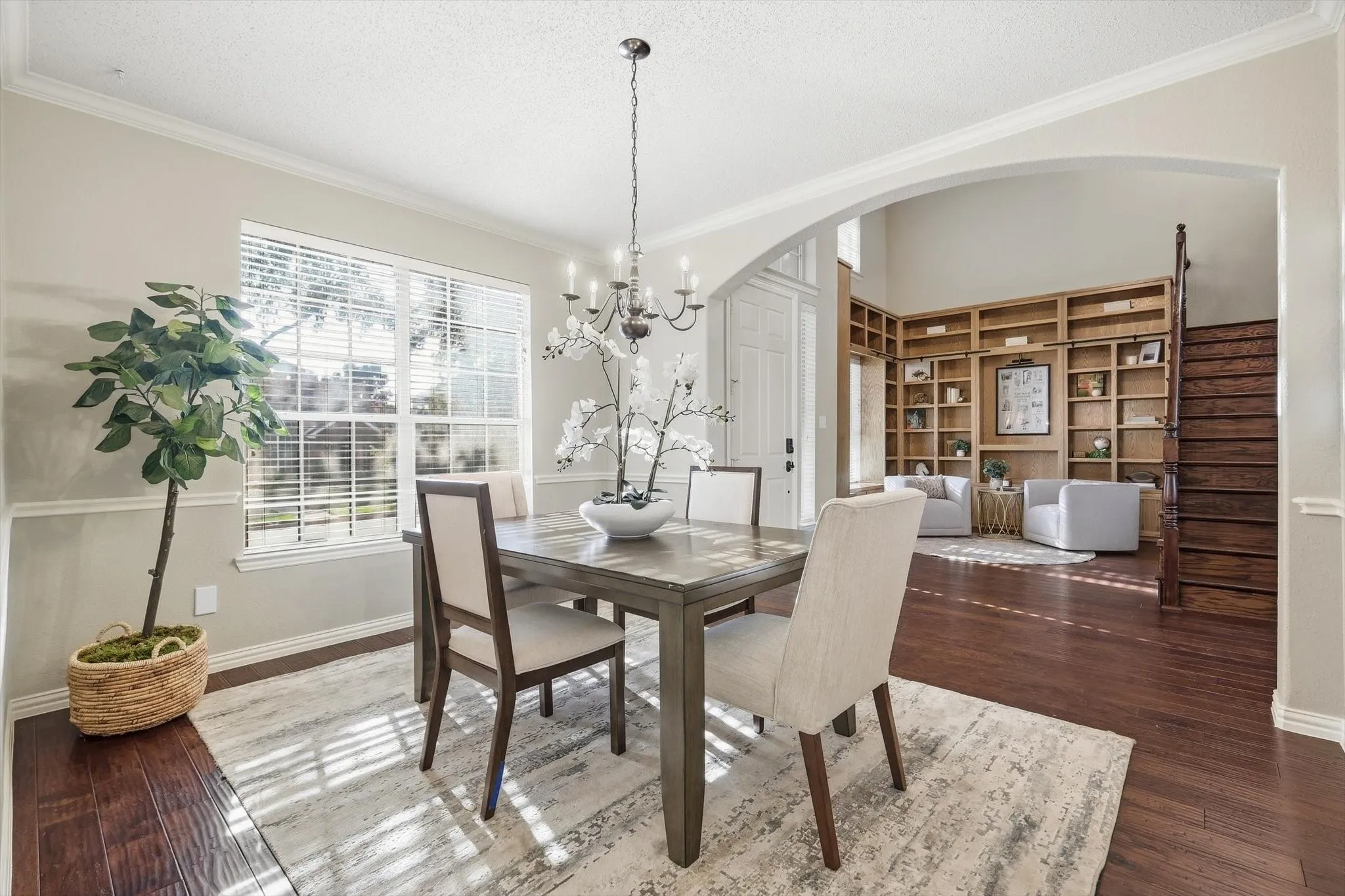 Hardwood flooring throughout, archway entry, built-in shelving, and a prominent window